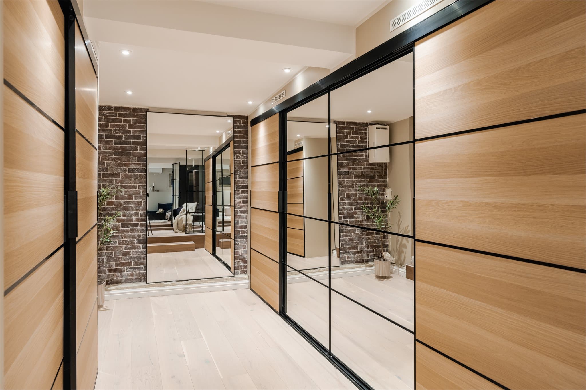 Garderobeskapene har fronter i tre og speil, som gir en varm og moderne følelse.