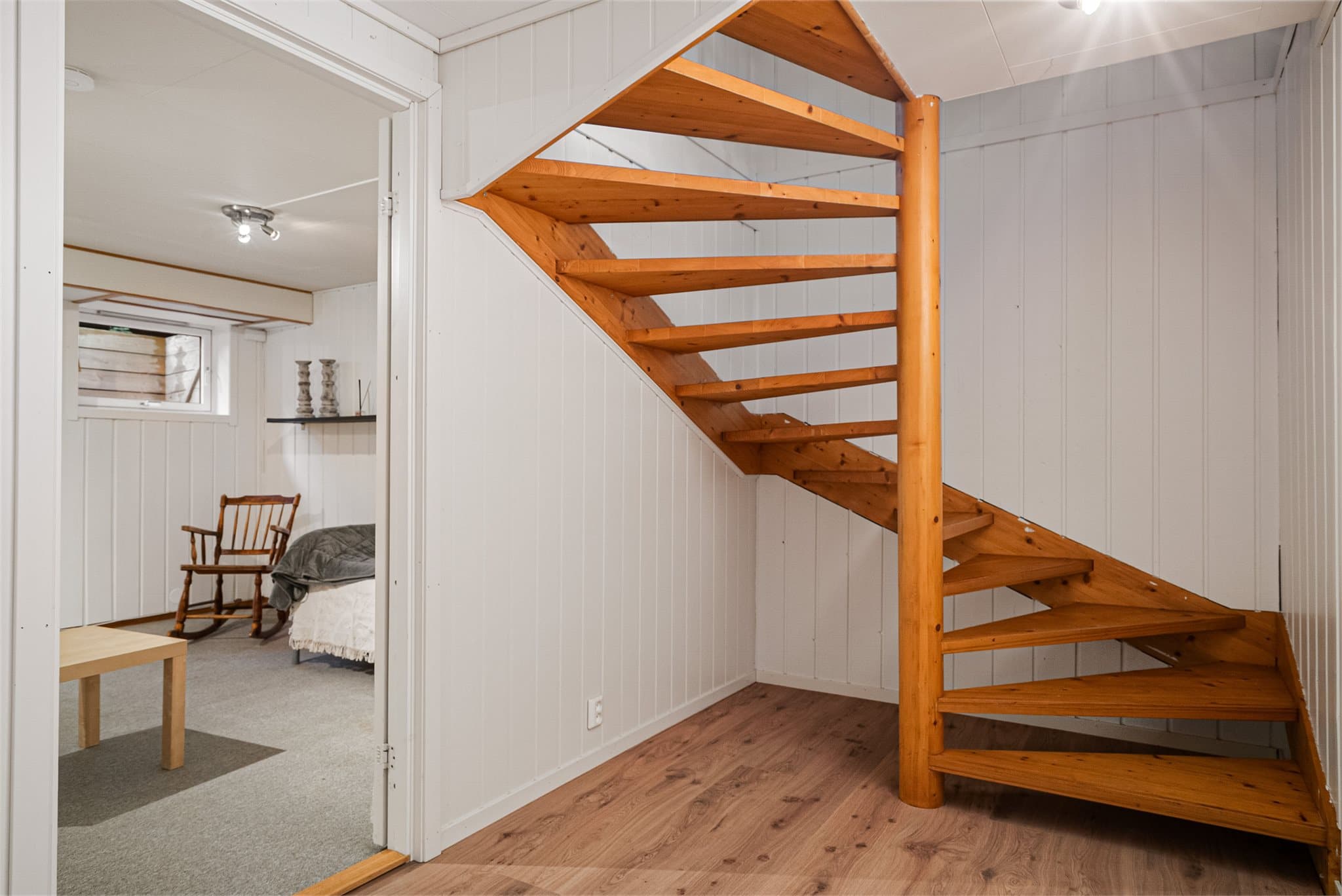 Gang i underetasjen med adkomst til bod og et rom som er innredet som kjellerstue.