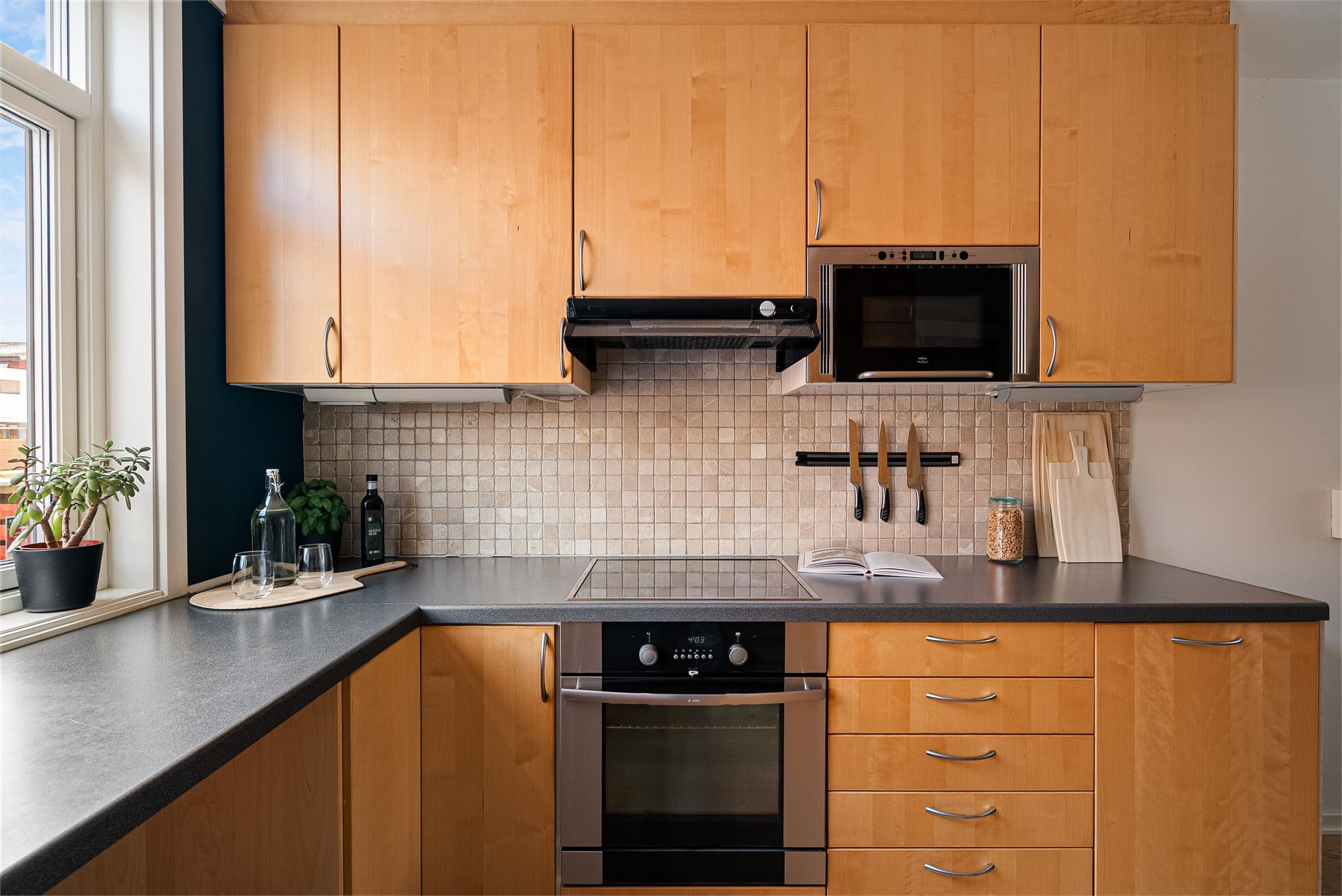 Kjøkkenet er godt utstyrt med skap og benkeplass.