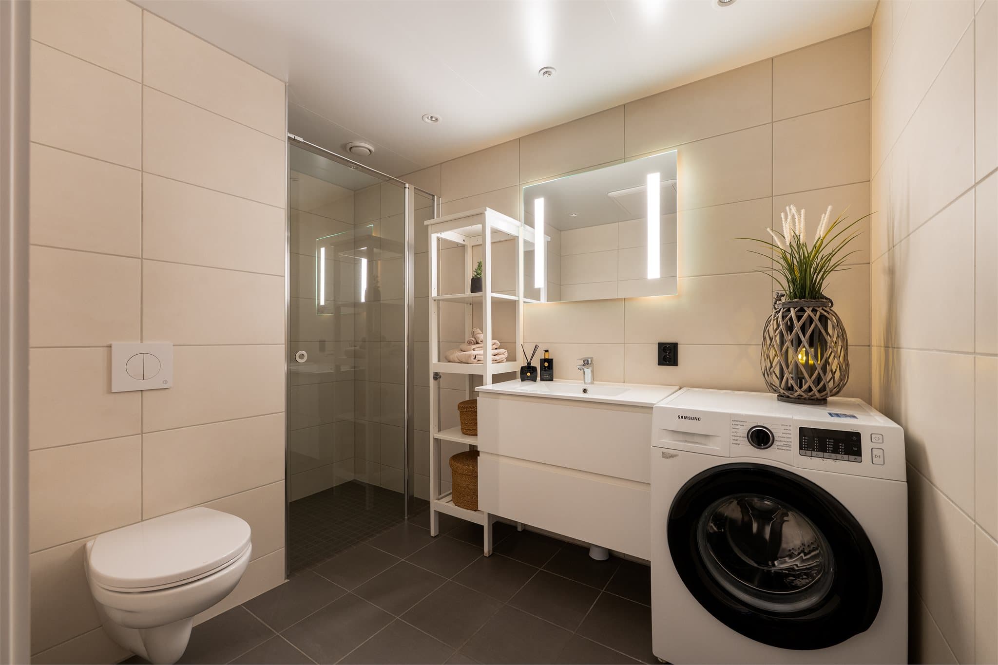 Fra gangen kommer man inn til et flott bad. Badet er en prefabrikkert baderomskabin og har fliser på vegger og gulv med vannbåren gulvvarme.