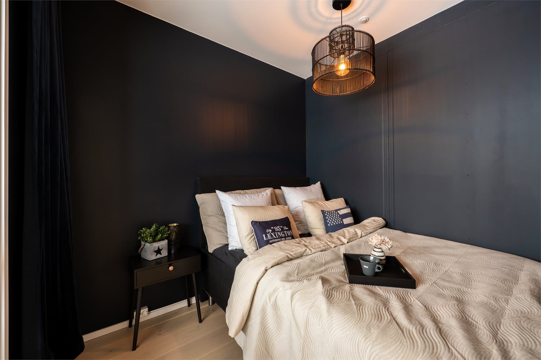 Leiligheten har ett soverom som er malt i en behagelig og mørk blånyanse.