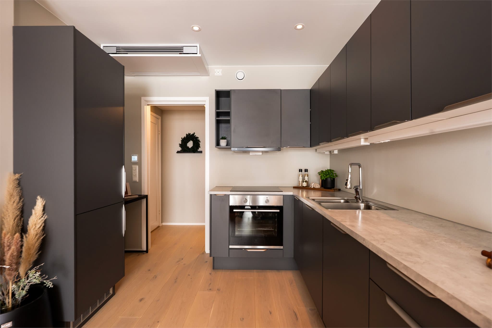 Flott kjøkkeninnredning fra Norema med mørke, stilrene fronter og laminat benkeplate.