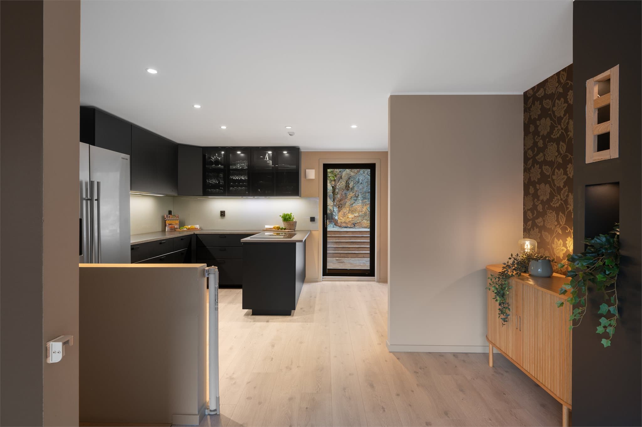 - Kjøkkenet måler 18,5m² og har kjøkkeninnredning med slette fronter og benkeplate i laminat med nedfelt vask -