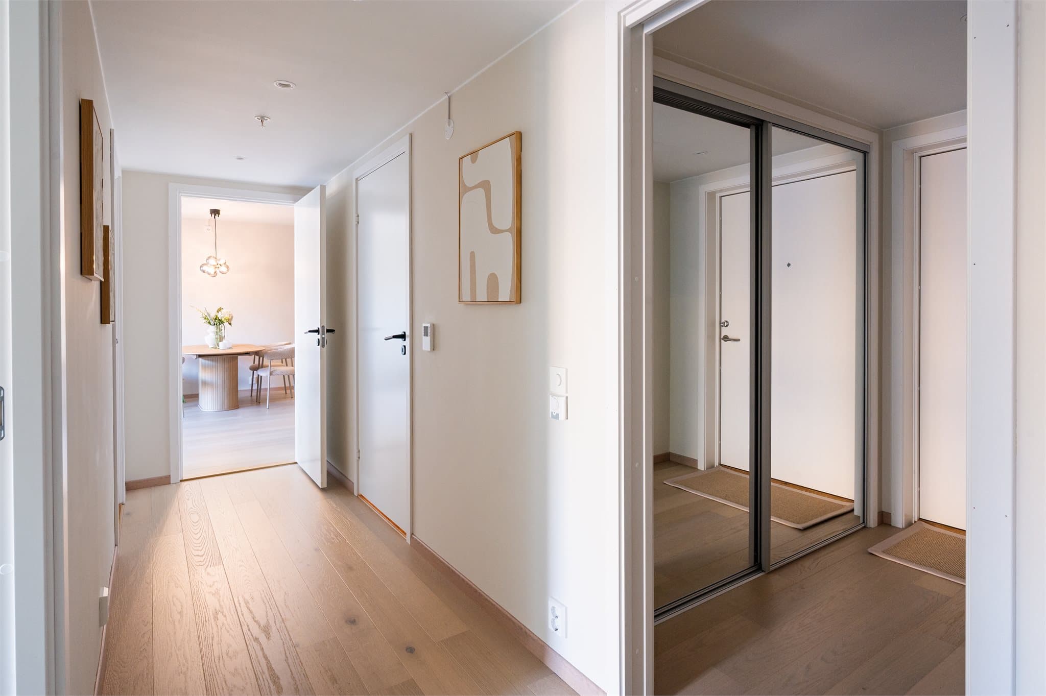 Elegant entré med rene linjer og garderobeløsning med speilfronter – en smakfull velkomst til hjemmet.