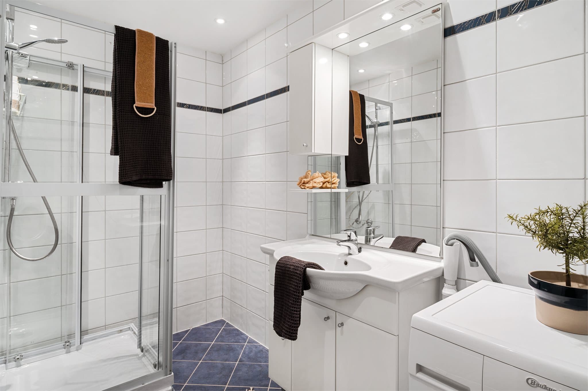 - Badet er innredet med heldekkende servant, opplegg for vaskemaskin og dusjkabinett -