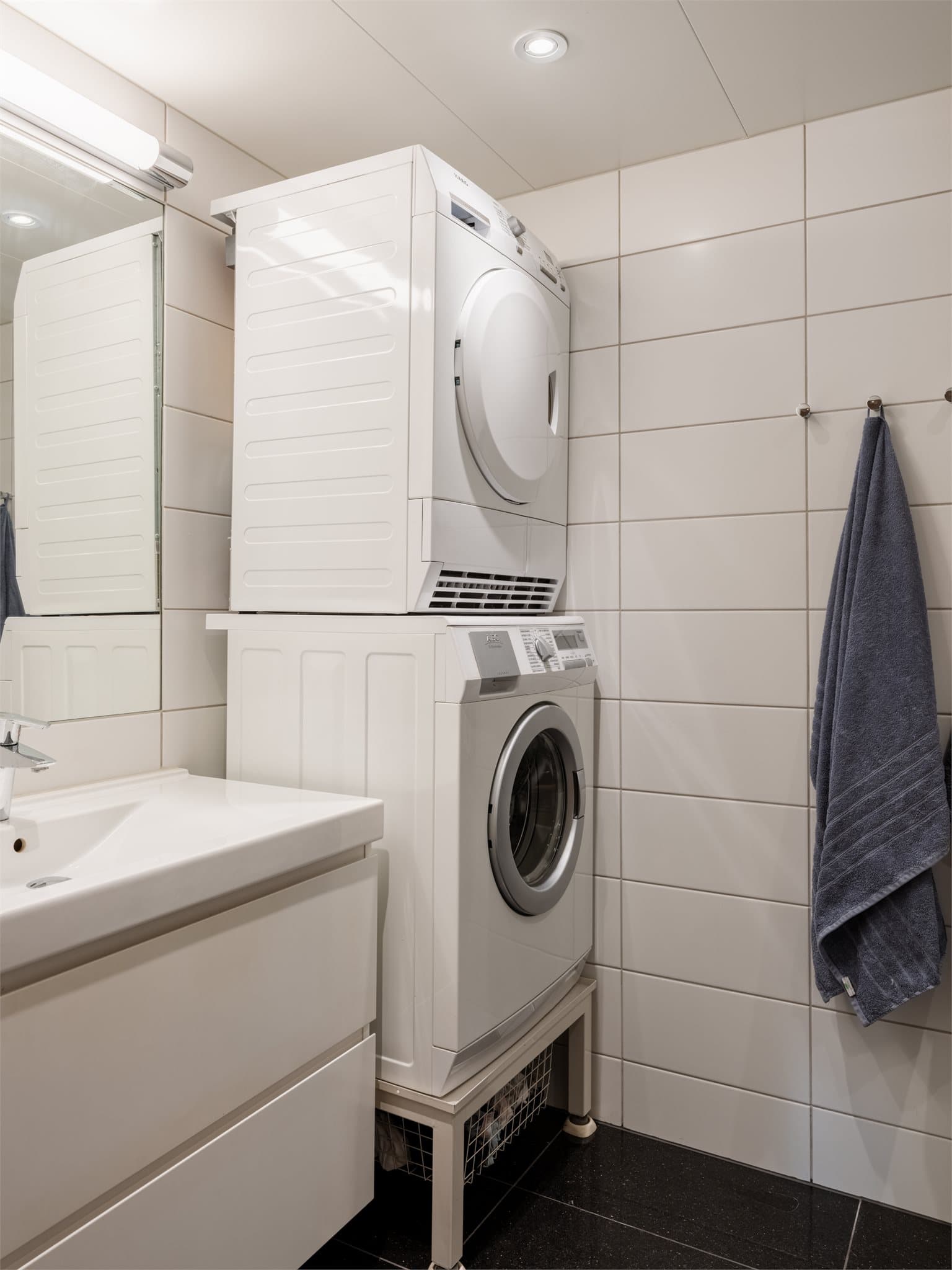 Leilighetens hovedbad er flislagt og har opplegg for vaskemaskin og tørketrommel.