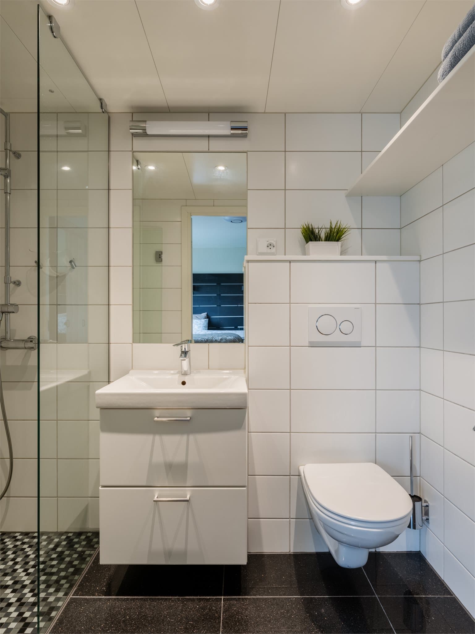 Dette badet er tilknyttet hovedsoverommet og har elektriske varmekabler i gulvet og dusjhjørne med glassvegger.
