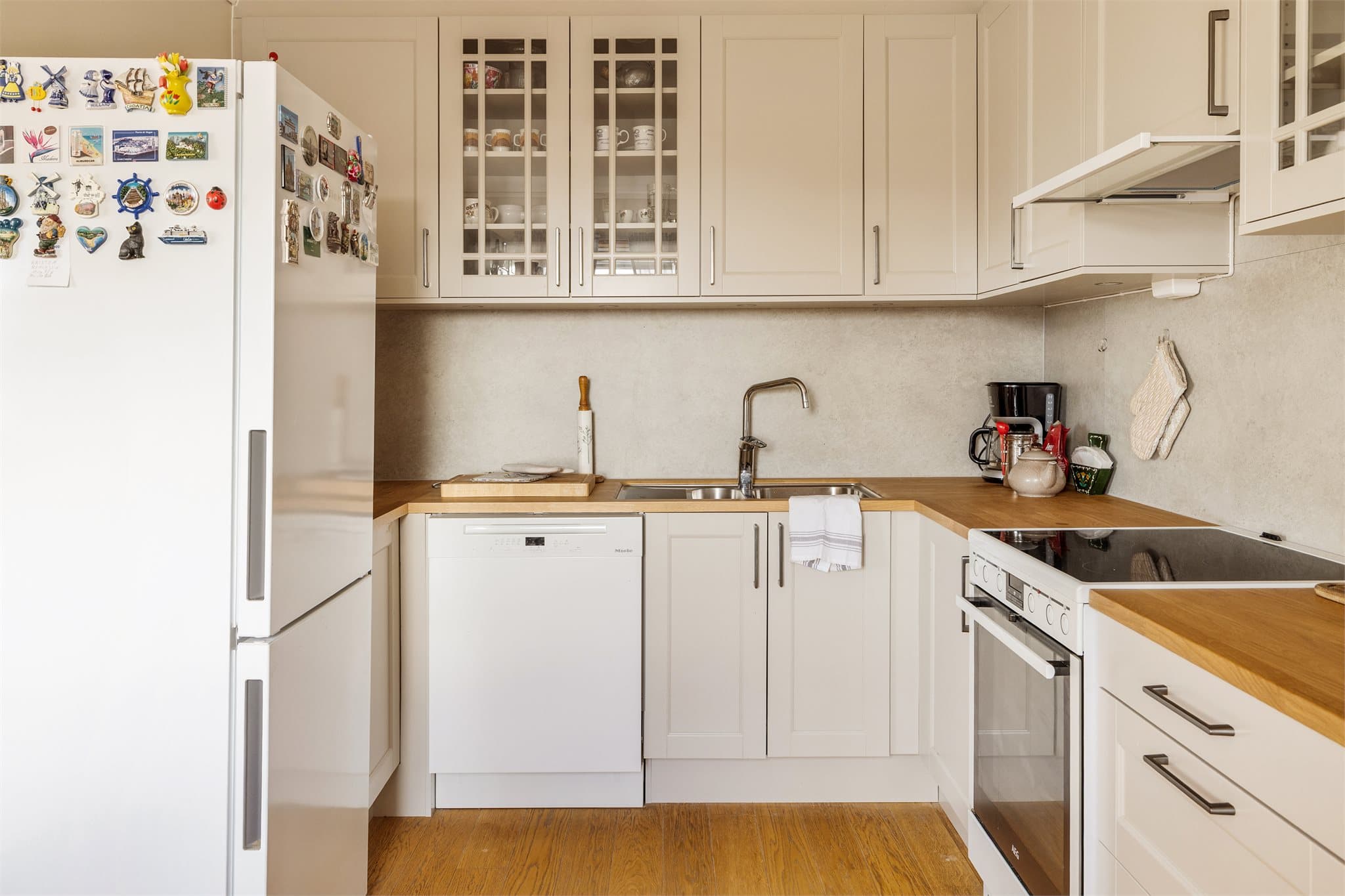 - Kjøkkeninnredning fra Norema med profilerte fronter/vitrineskap og benkeplate i tre -