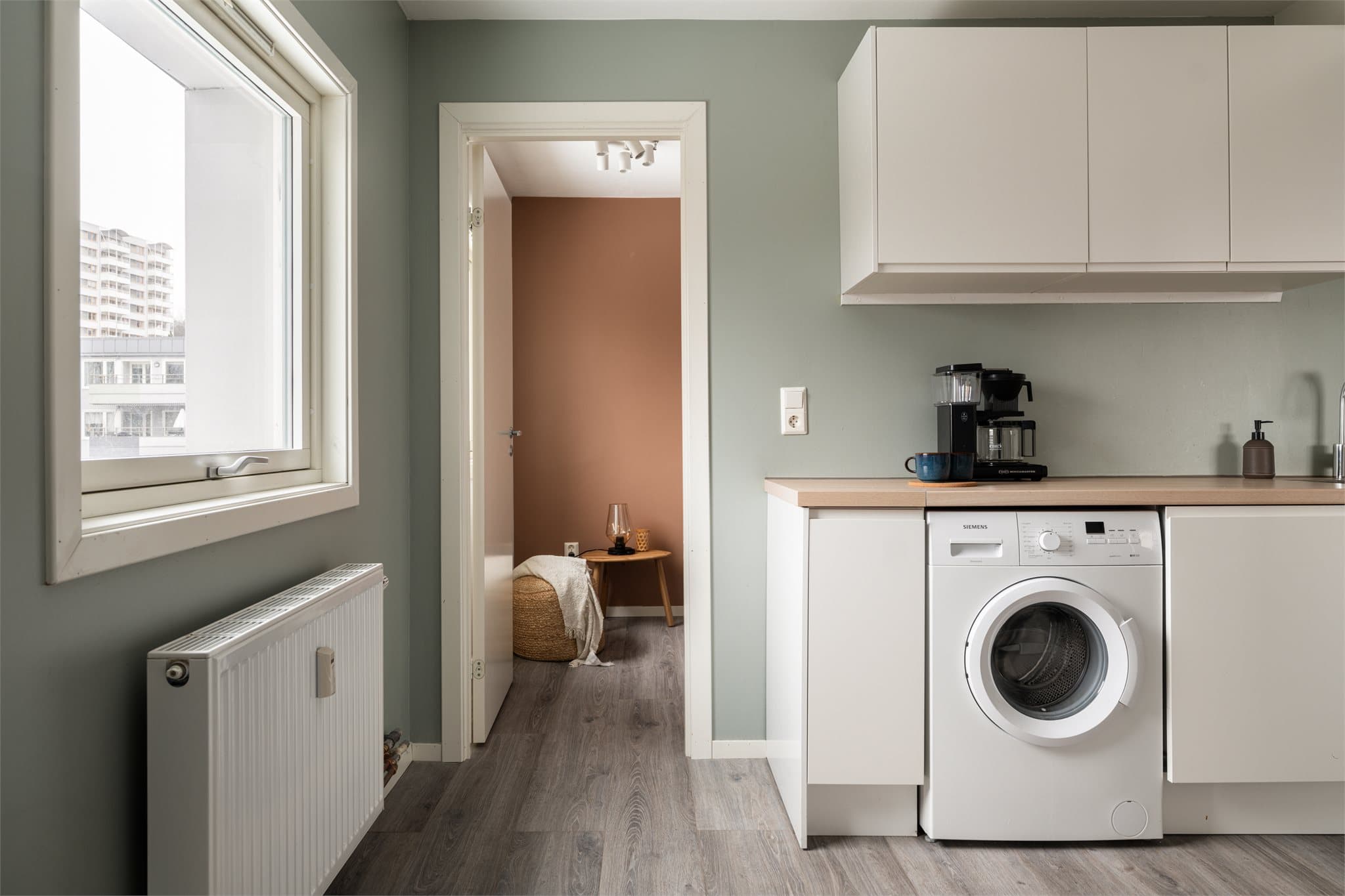 Egen nisje for vaskemaskin på kjøkkenet.