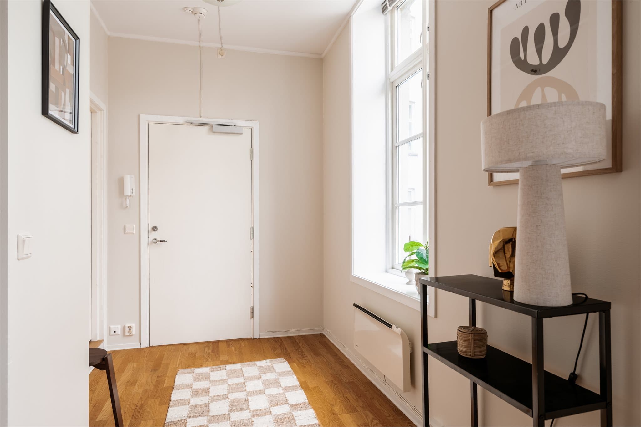 En lys entre som ønsker deg velkommen inn. Her er det montert porttelefon som gjør det enkelt å slippe inn gjester.