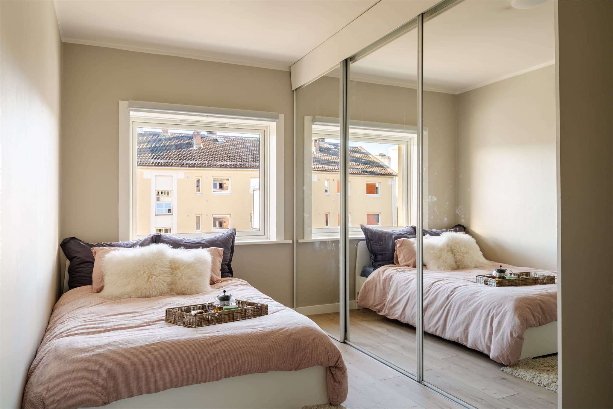 Videre er det plass til klesoppbevaring i stor skyvedørsgarderobe med speilfronter.