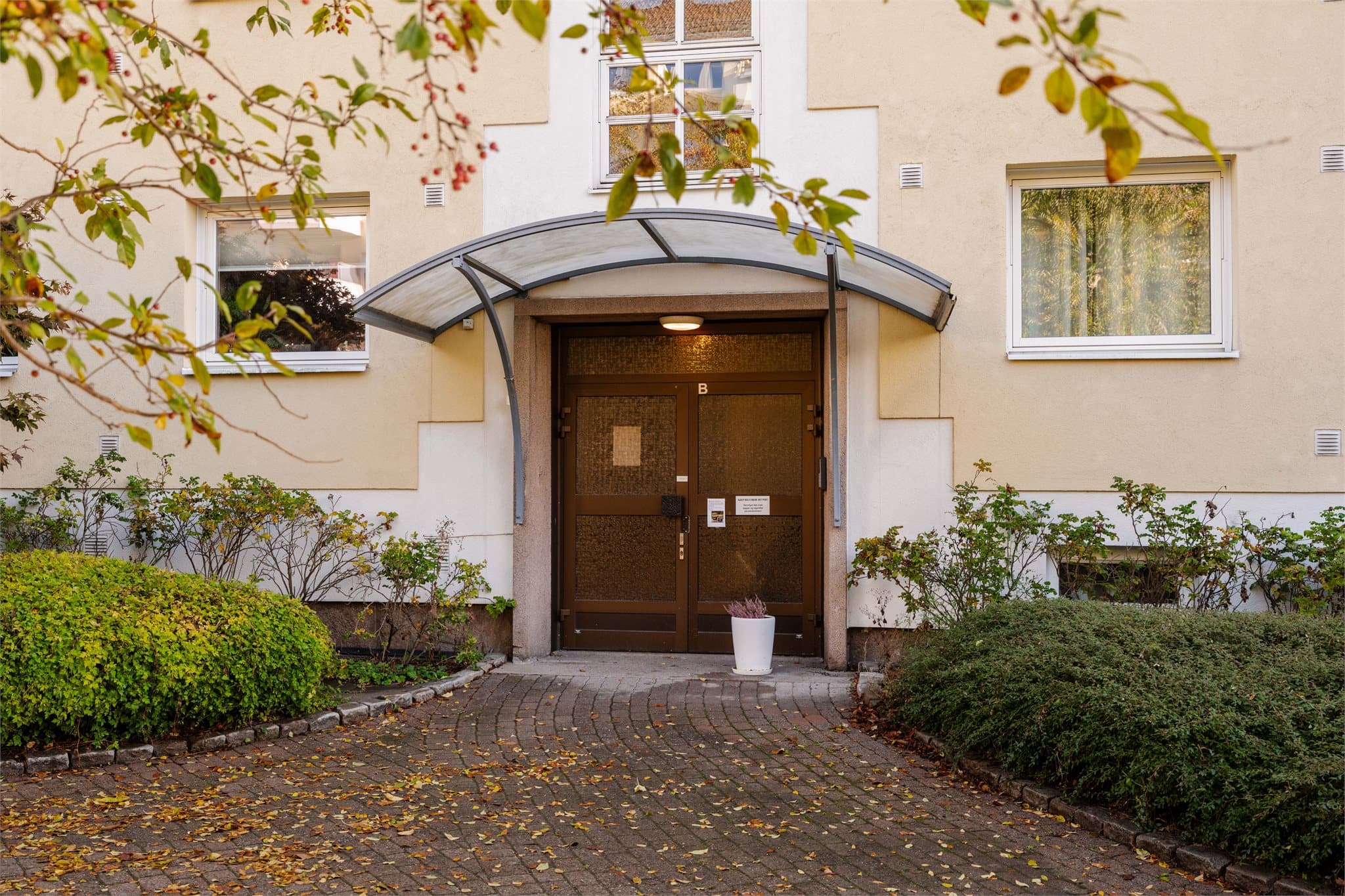 Overbygget inngangsparti fra bakkeplan.
