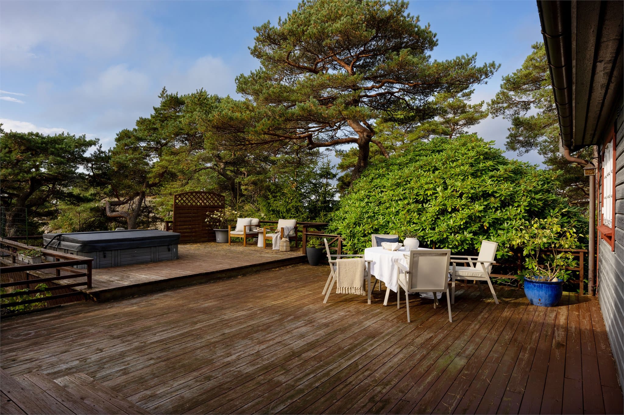 Terrasse i tre med nedfelt massasjebad og trappetrinn.