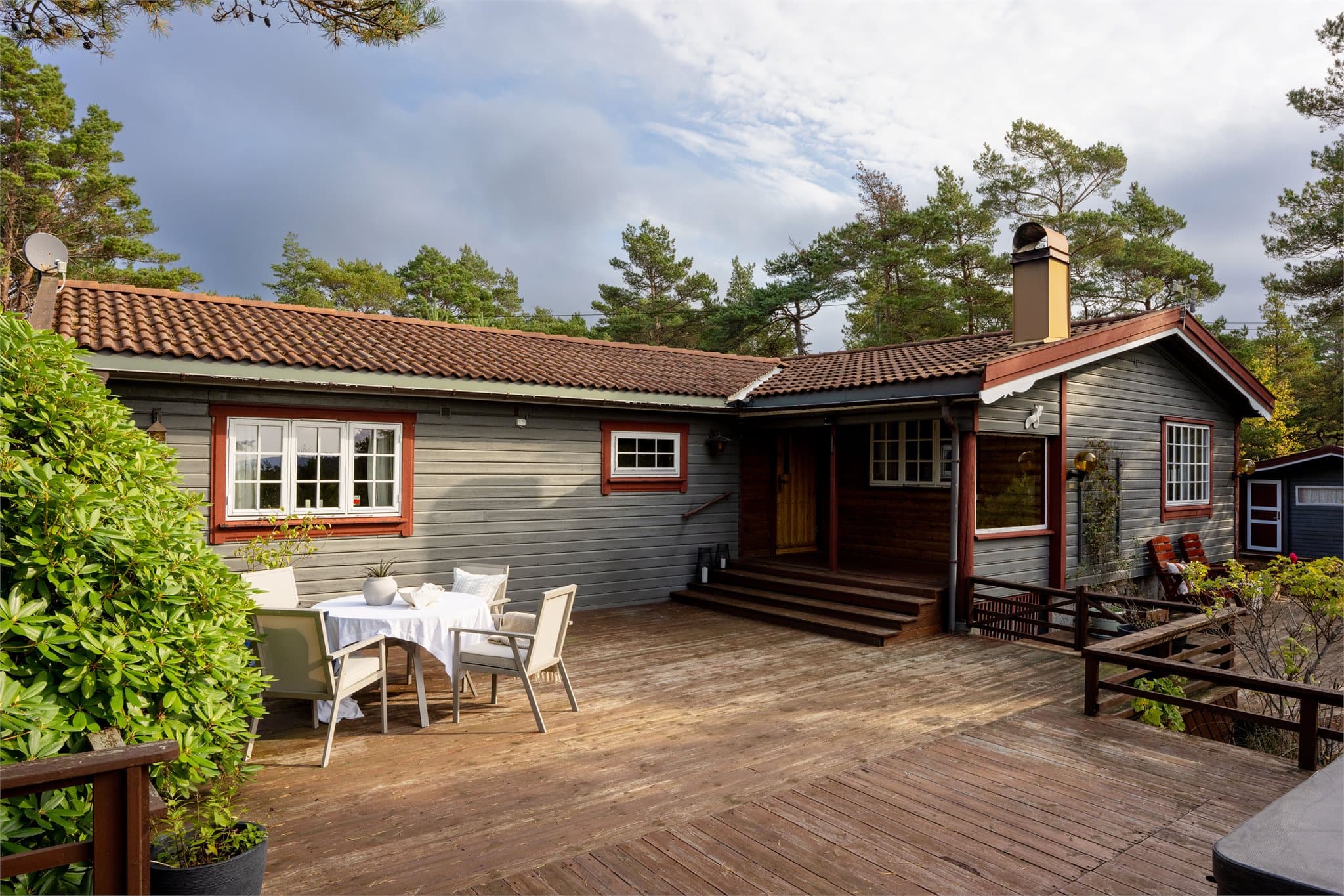 Terrasse i trekonstruksjon fundamentert på trepilarer og lettklinkerblokker.