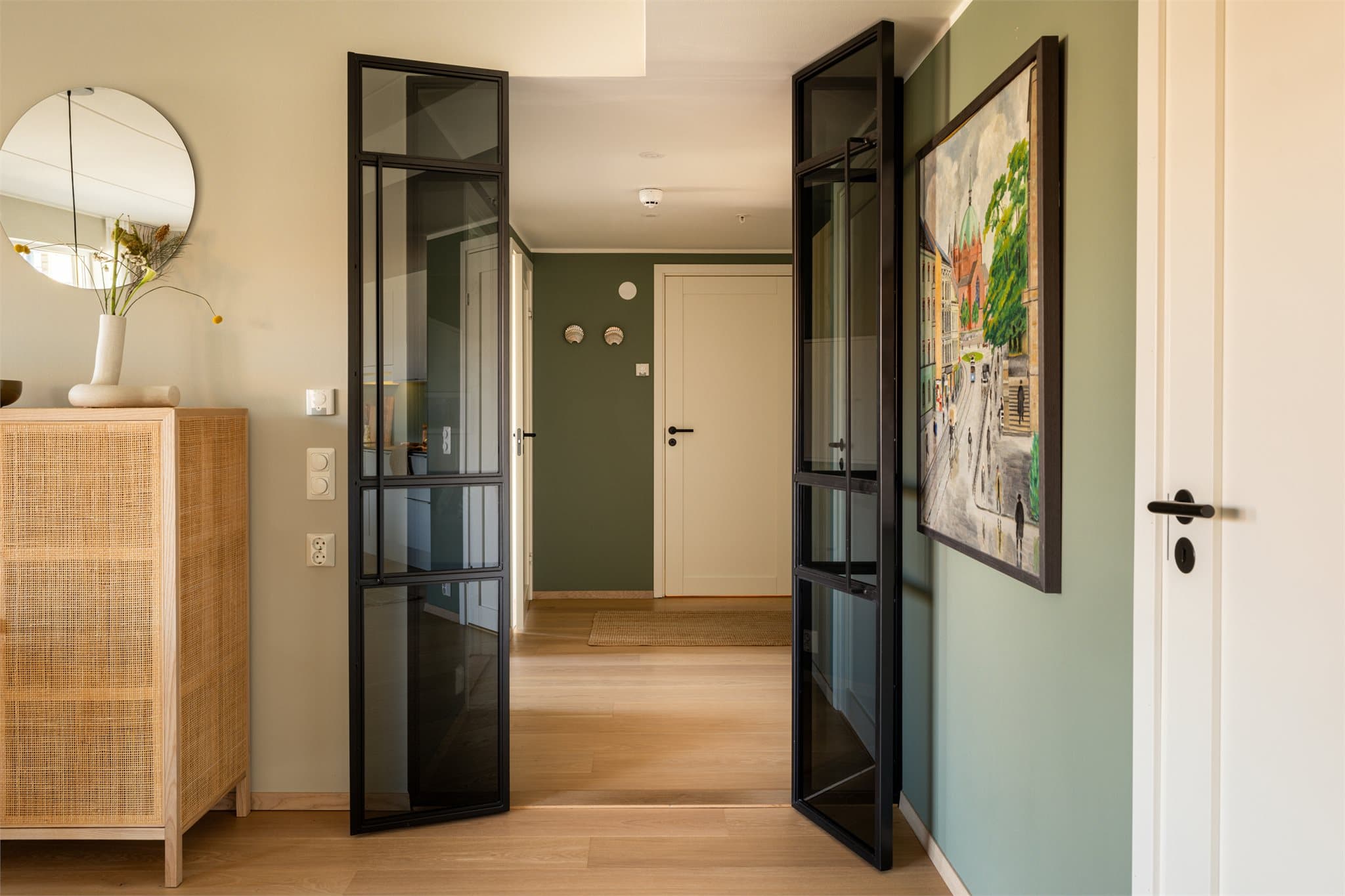 Smijernsdører skaper en elegant overgang mellom stue og entré, og tilfører boligen et eksklusivt preg.