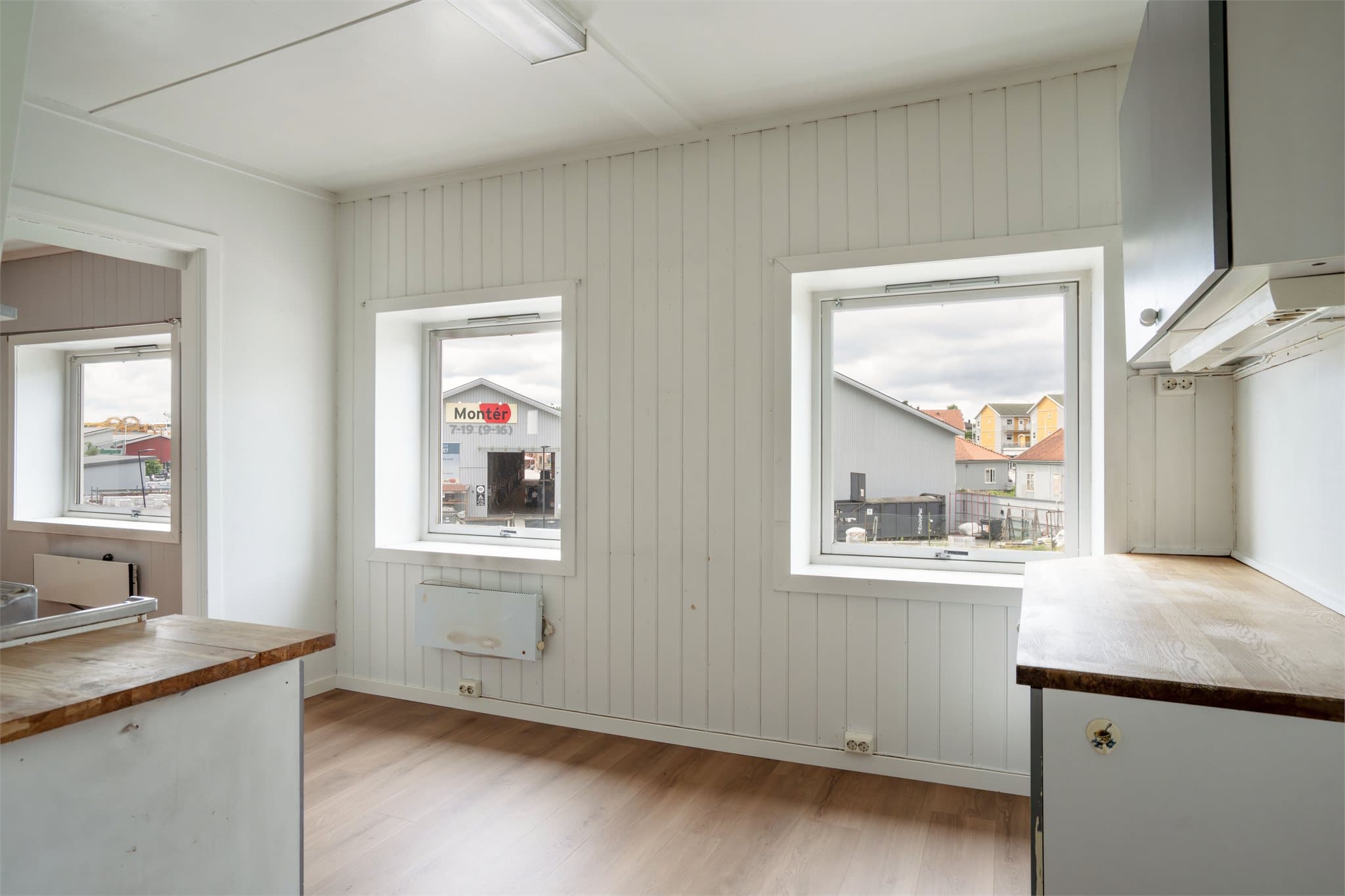 Kjøkkenet har en eldre, plassbygd innredning med benkeplate i heltre og rustfritt stål.