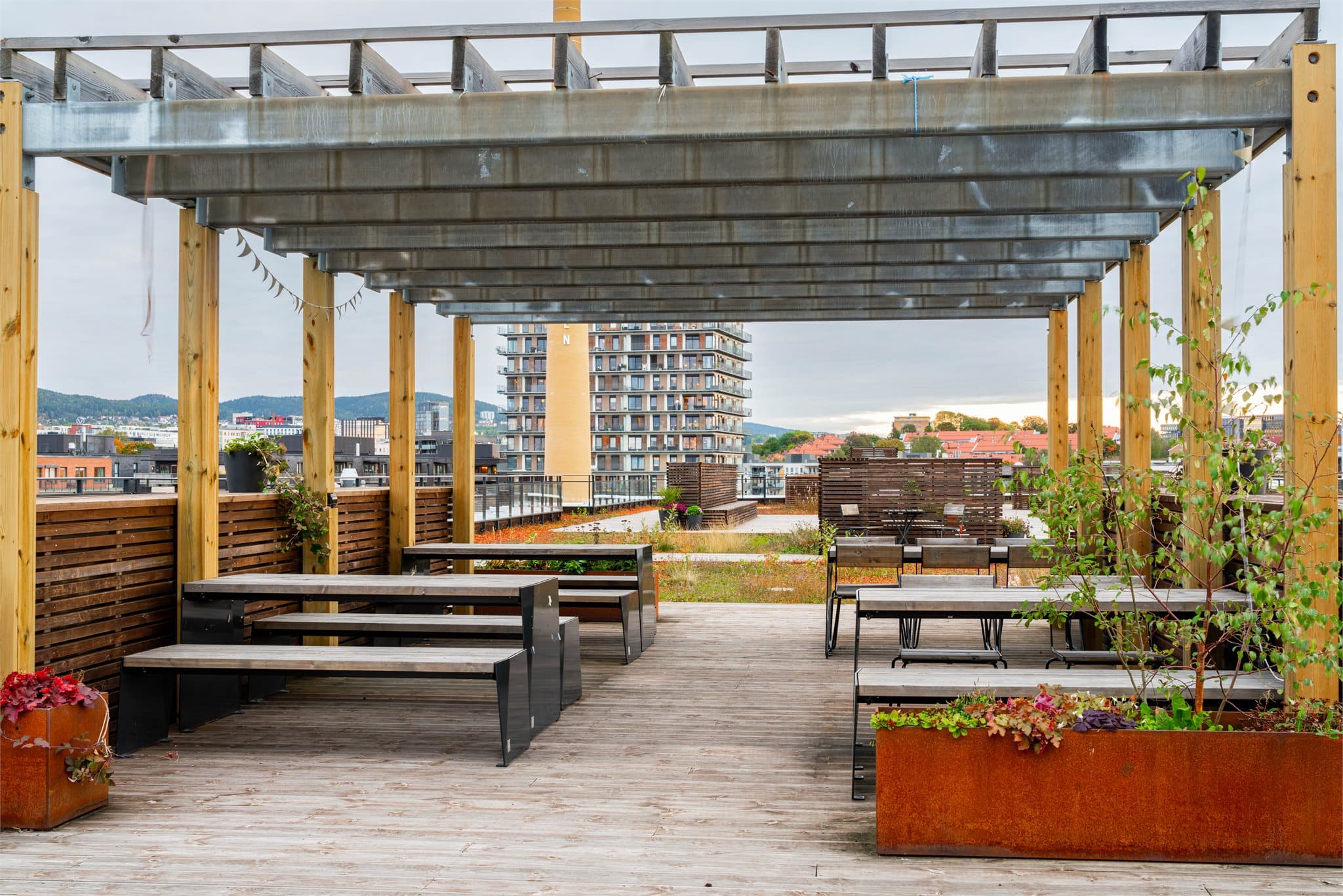 Takterrassen byr på mange sittegrupper, solstoler og frodige planter.