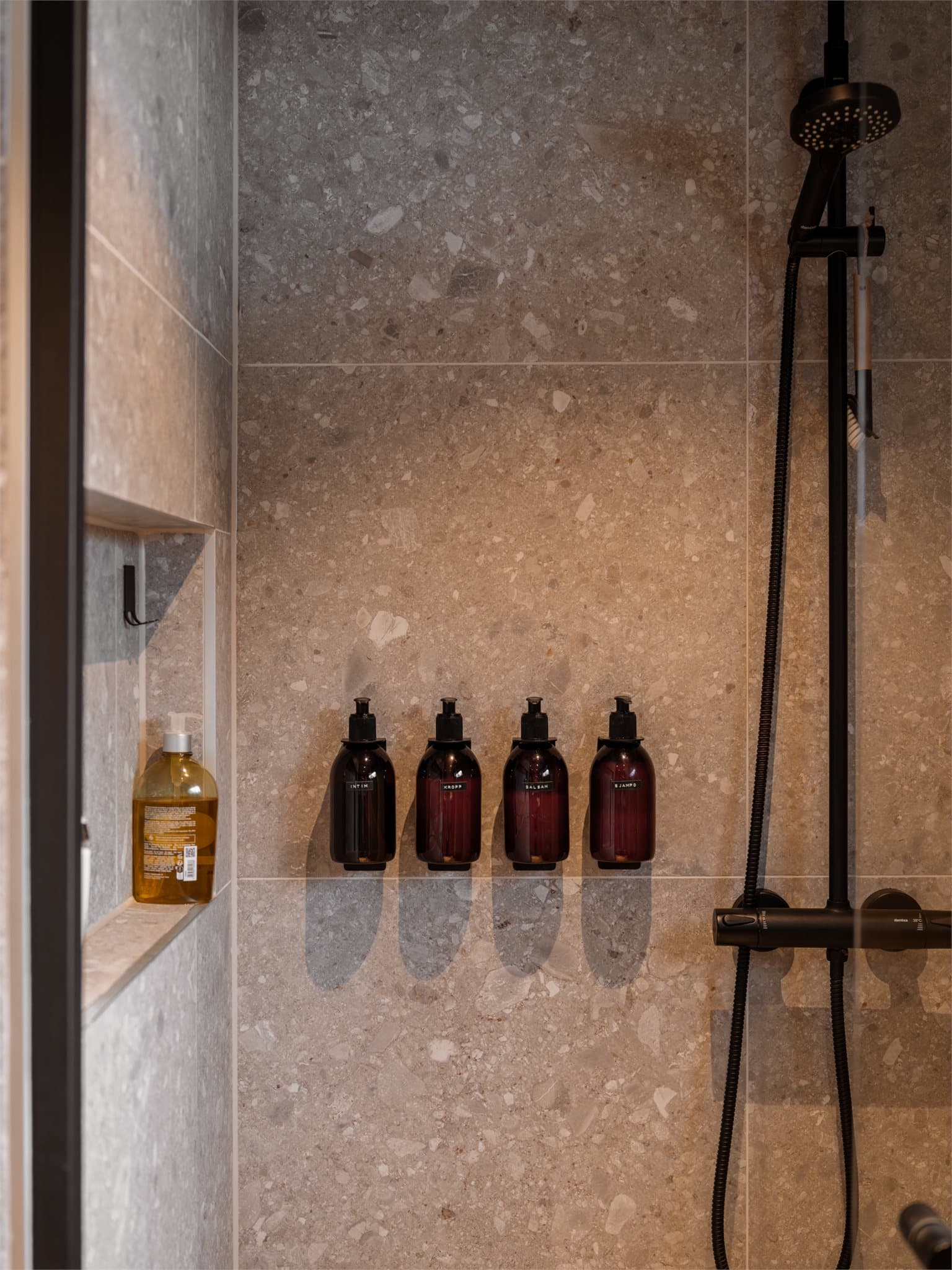 I dusjsonen er det innfelt en praktisk nisje for oppbevaring av såper og lignende.