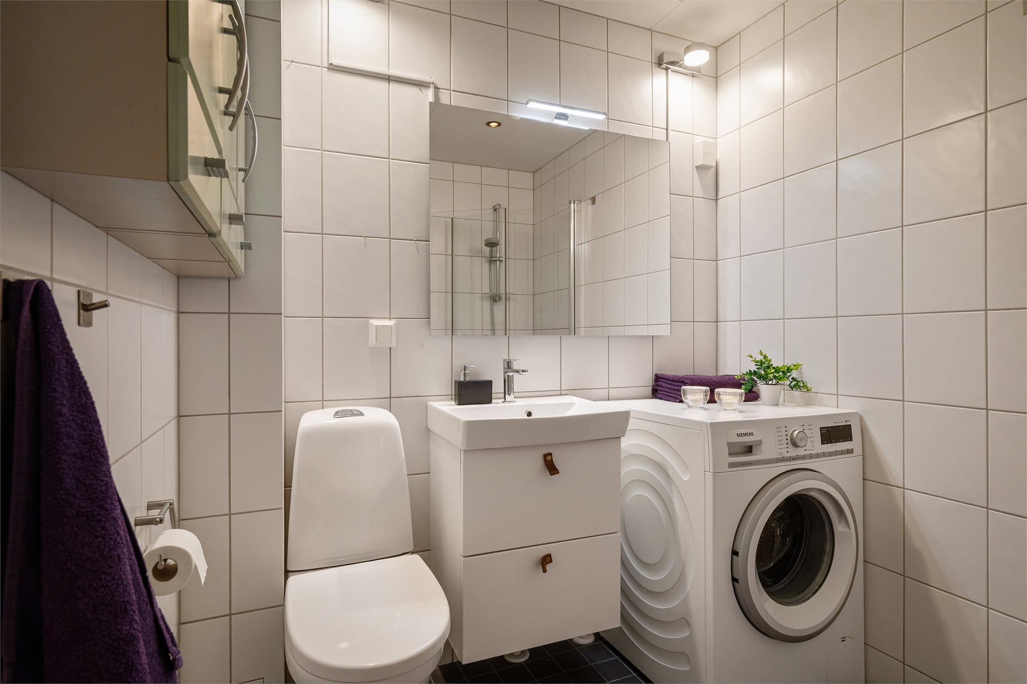 Flislagt bad med opplegg for vaskemaskin.