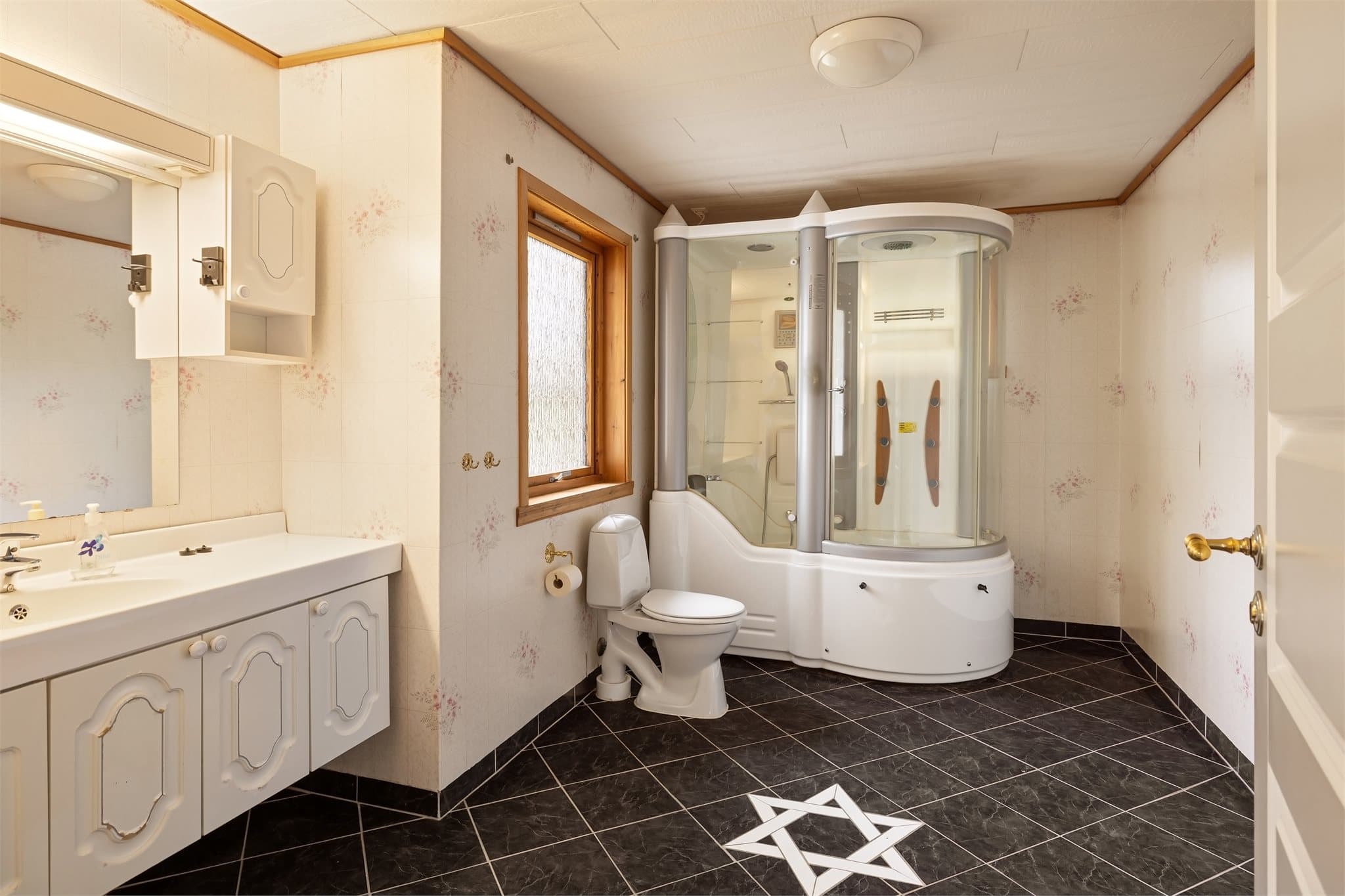 Badet måler hele 11,1m² og har keramiske fliser på gulv og våtromsvinyl på vegger