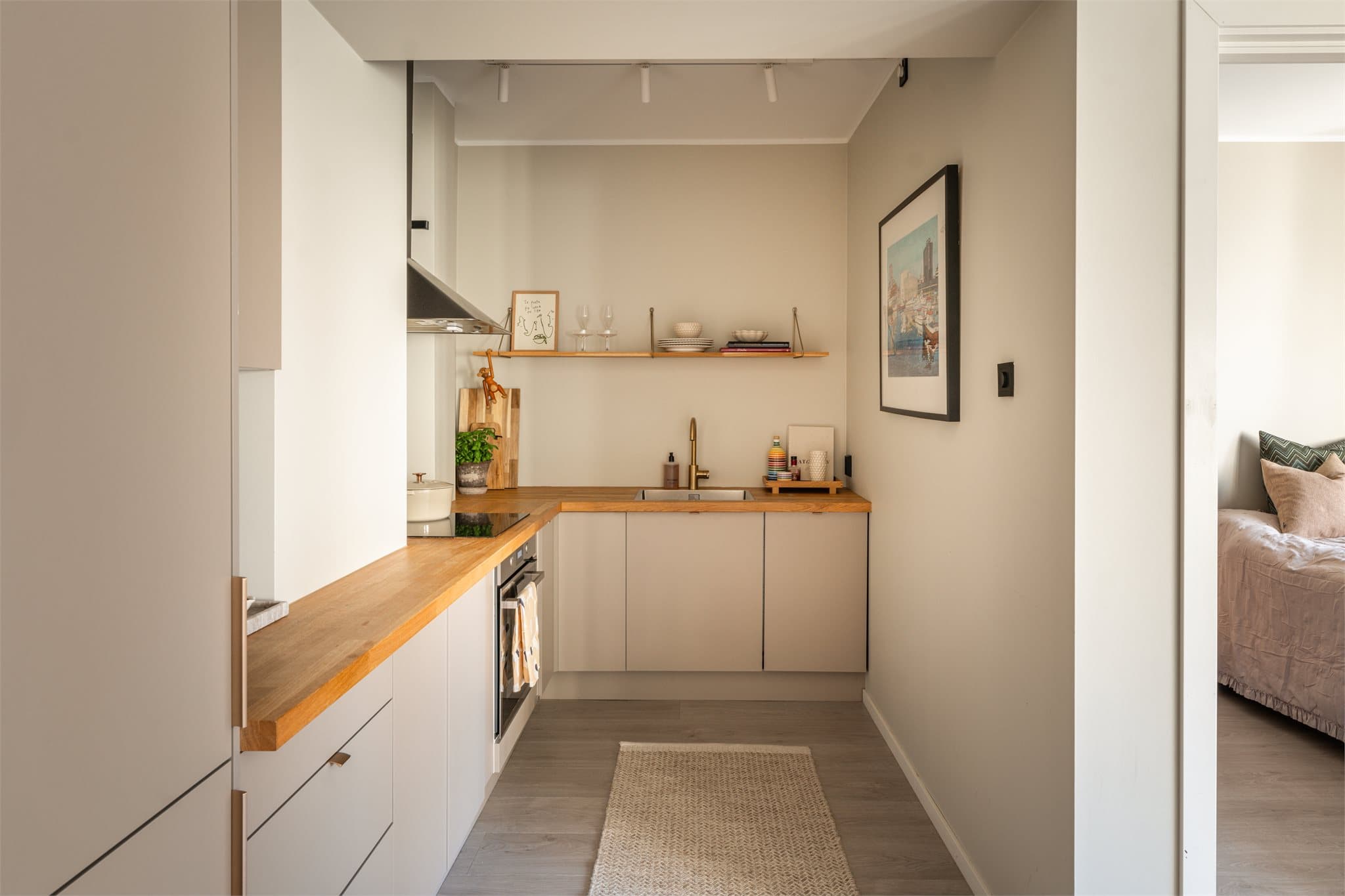 Kjøkkenet har et moderne og tidløst uttrykk med stilren innredning fra HTH, glatte fronter og benkeplate i heltre. Den åpne løsningen mot stuen gir en fin sammenheng mellom rommene og legger til rette for en sosial hverdag.