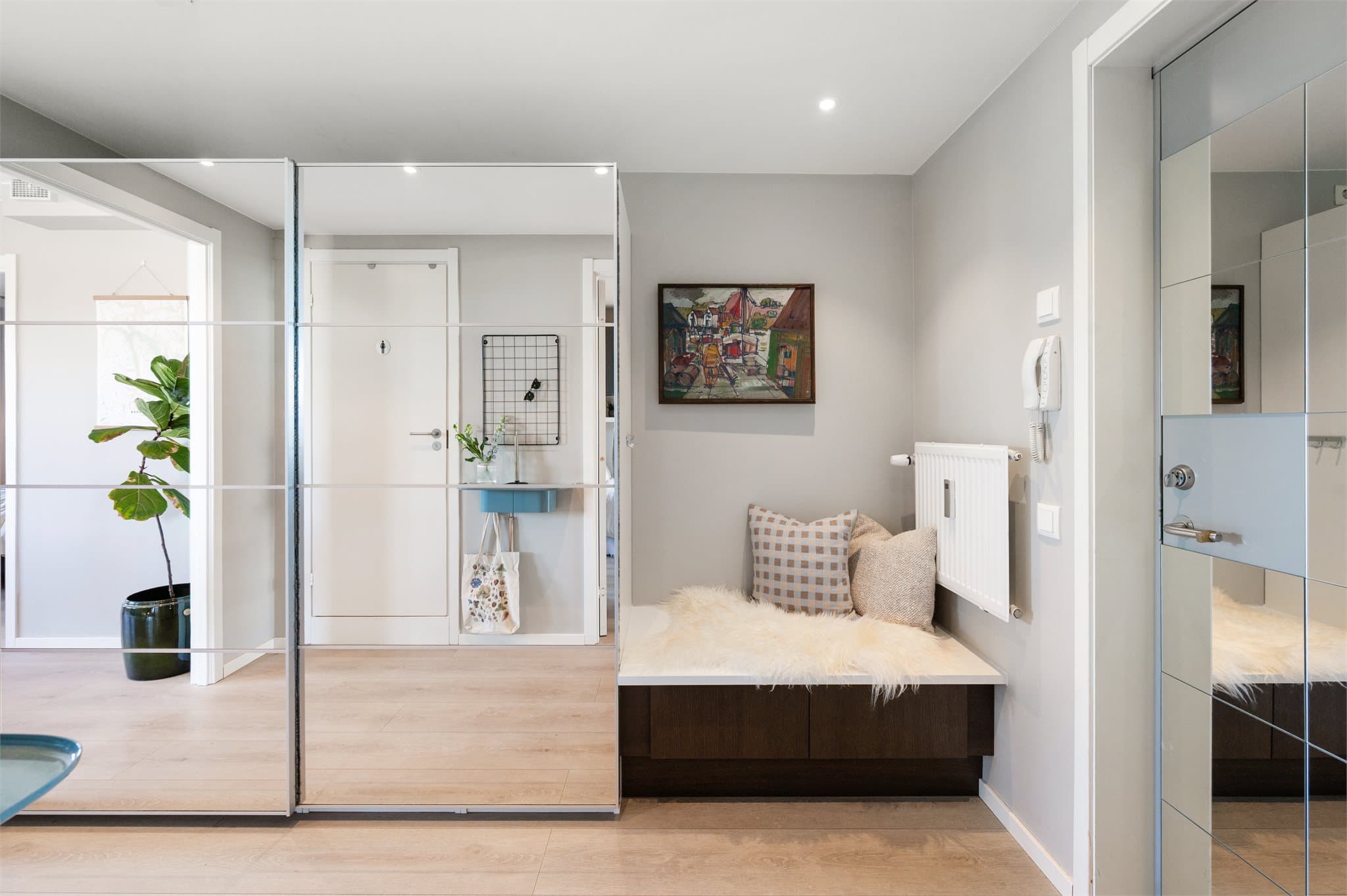 Dette er en lys og innbydende entré, med skyvedørsgarderobe.