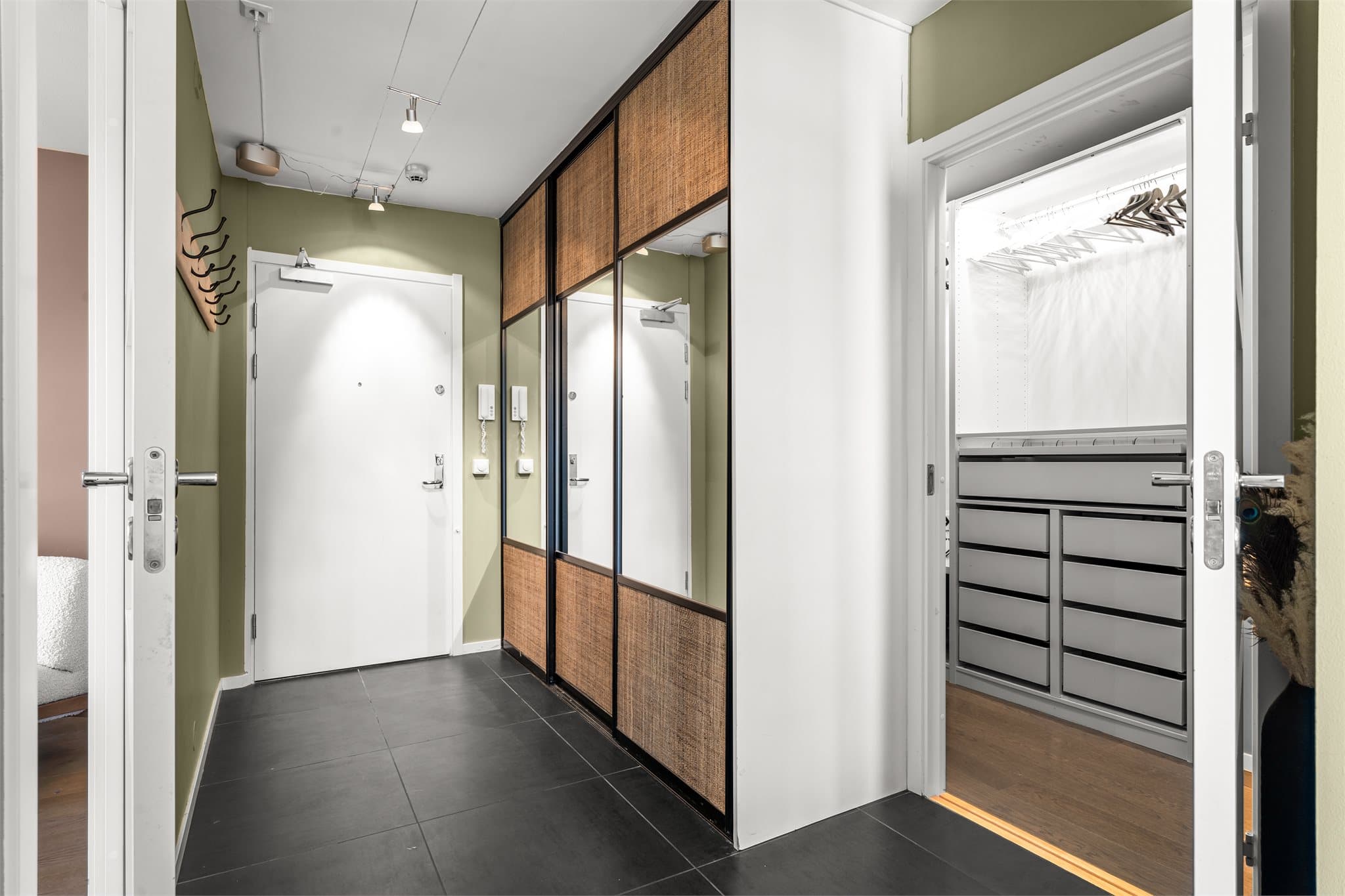 Her er det rikelig med oppbevaringsplass for sko og yttertøy i en plassbygget garderobeløsning, i tillegg til tilknytning til et praktisk omkledningsrom med gode skap- og hyllerløsninger.