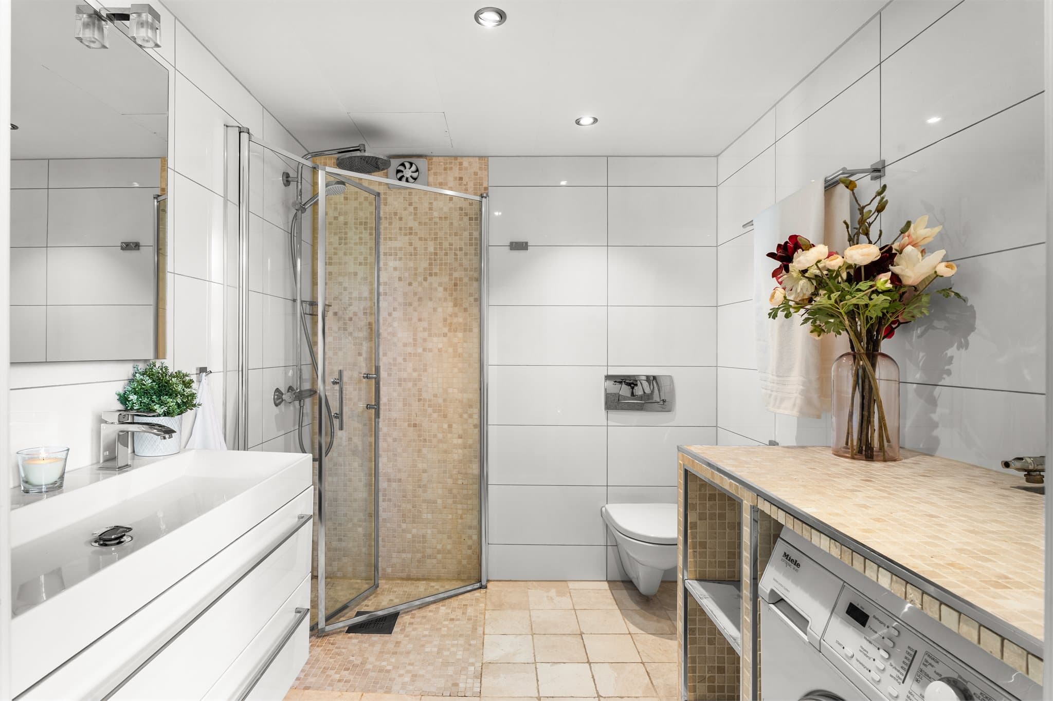 Flislagt bad oppgradert i 2012, med vegghengt toalett, dusj med innfellbare glassdører og opplegg for vaskemaskin.