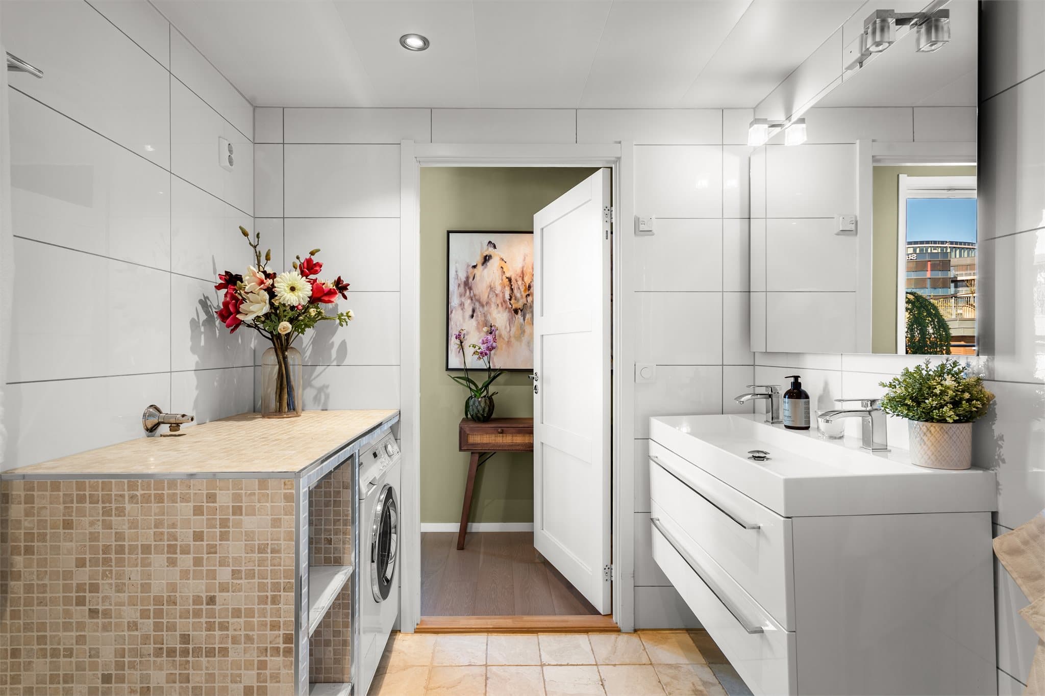 Badet har baderomsinnredning med benkeskap, servant og speil med belysning.