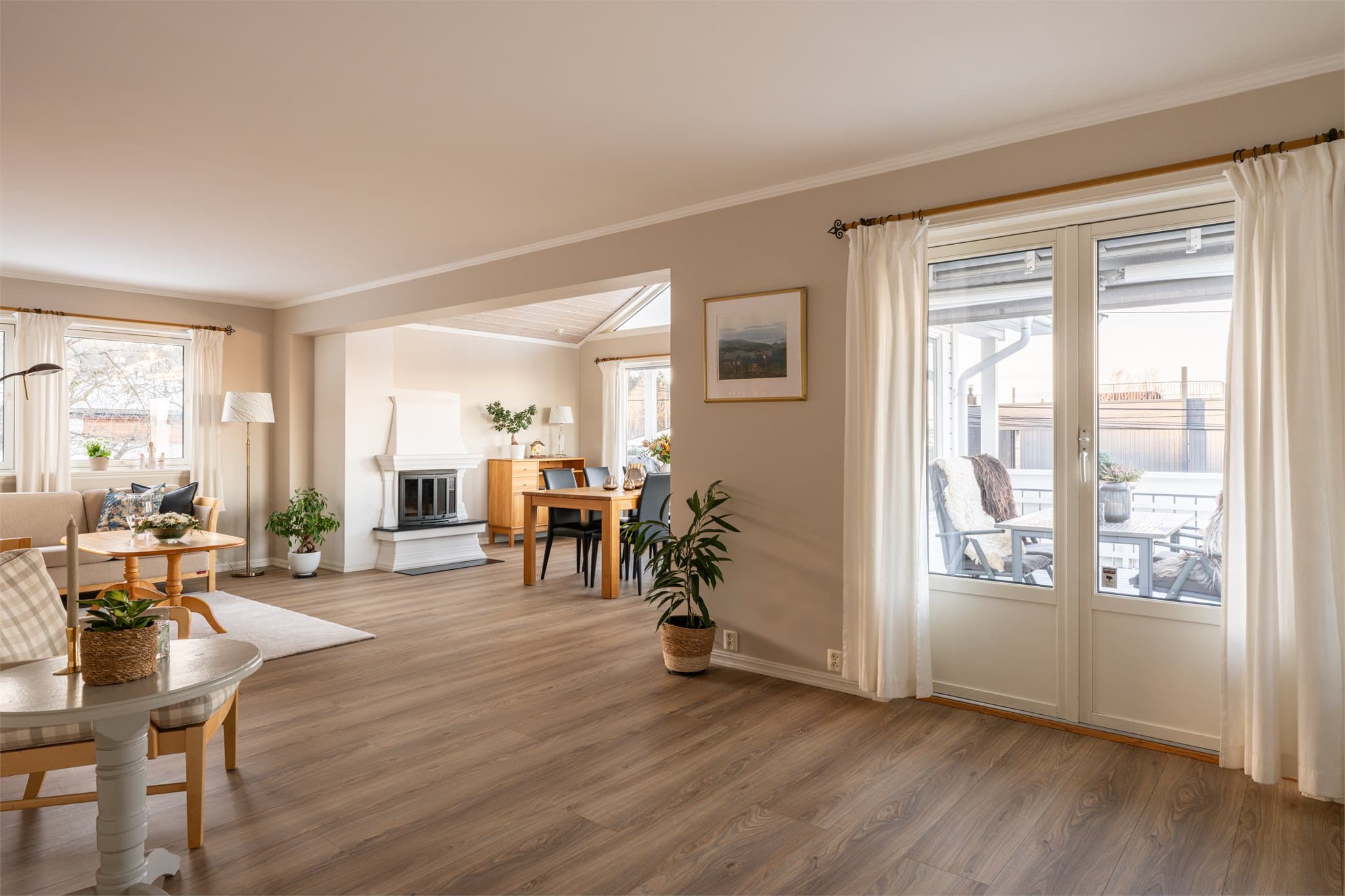 Et innbydende allrom med naturlig soneinndeling og mye naturlig lys fra store vindusflater.