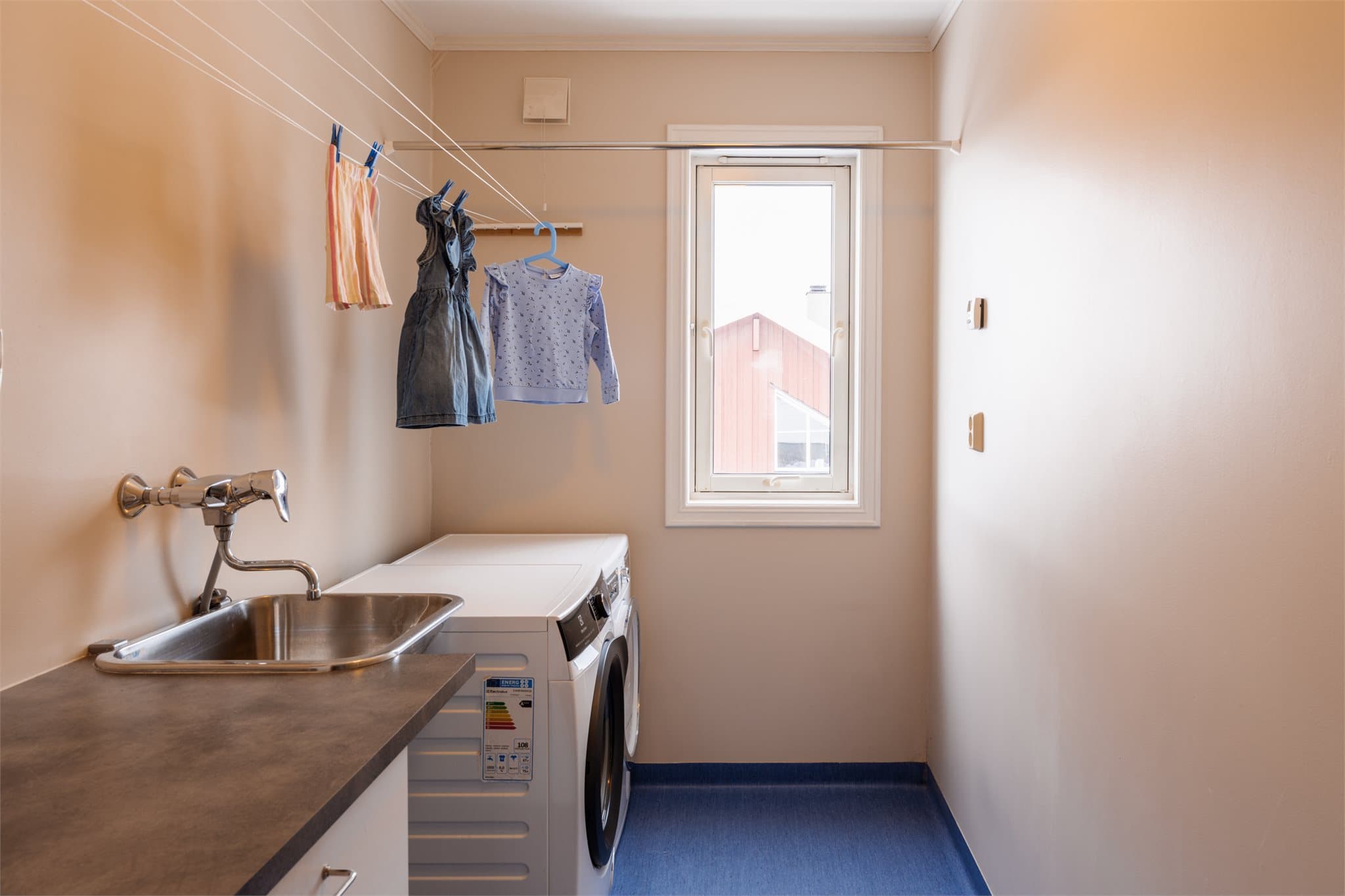 Vaskerom med utslagsvask, skap og opplegg for både vaskemaskin og tørketrommel.