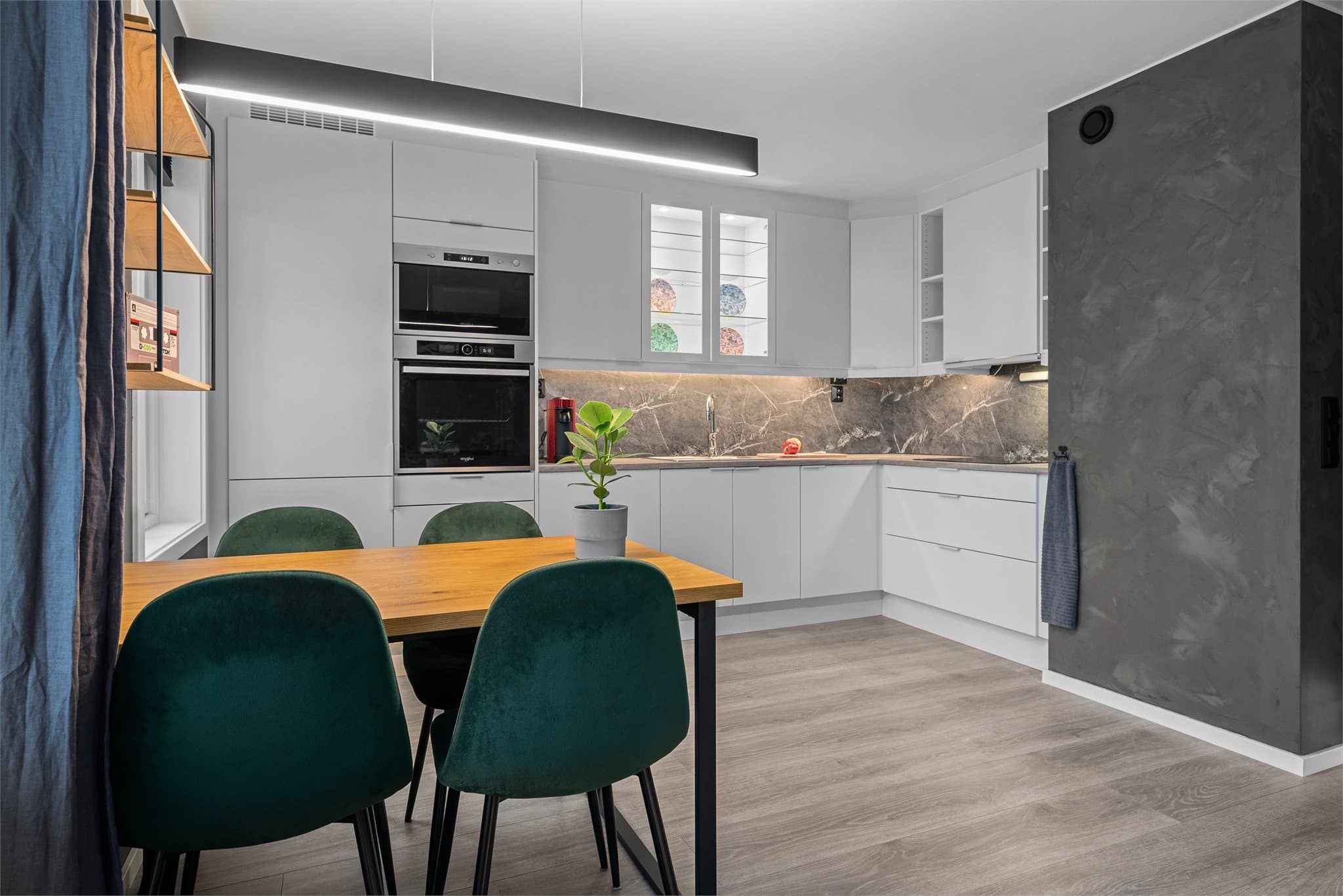 Stilren, hvit innredning, dels med vitrineskap.