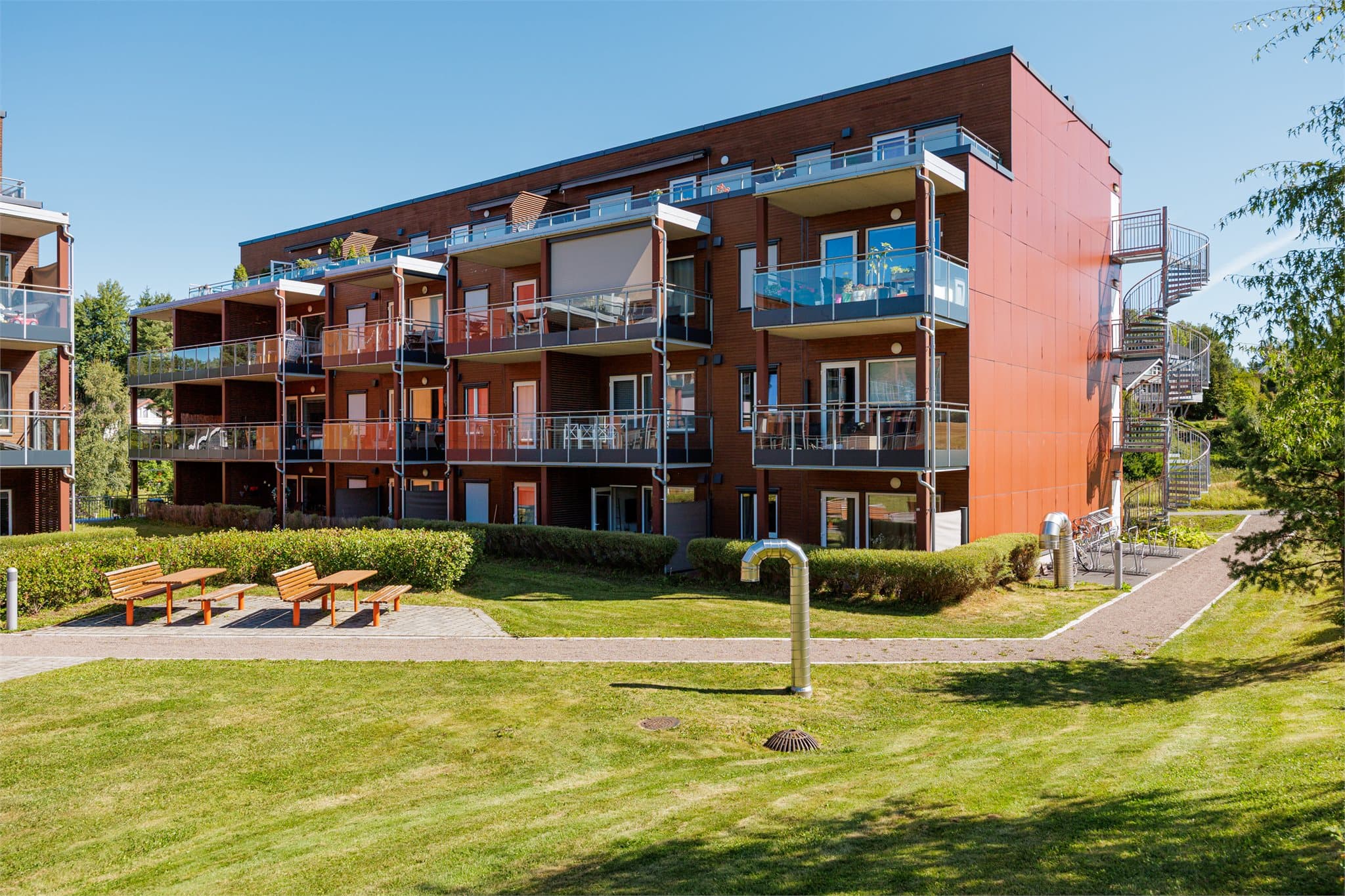 Nærområdet byr på fine grøntområder, benker og lekeplass.