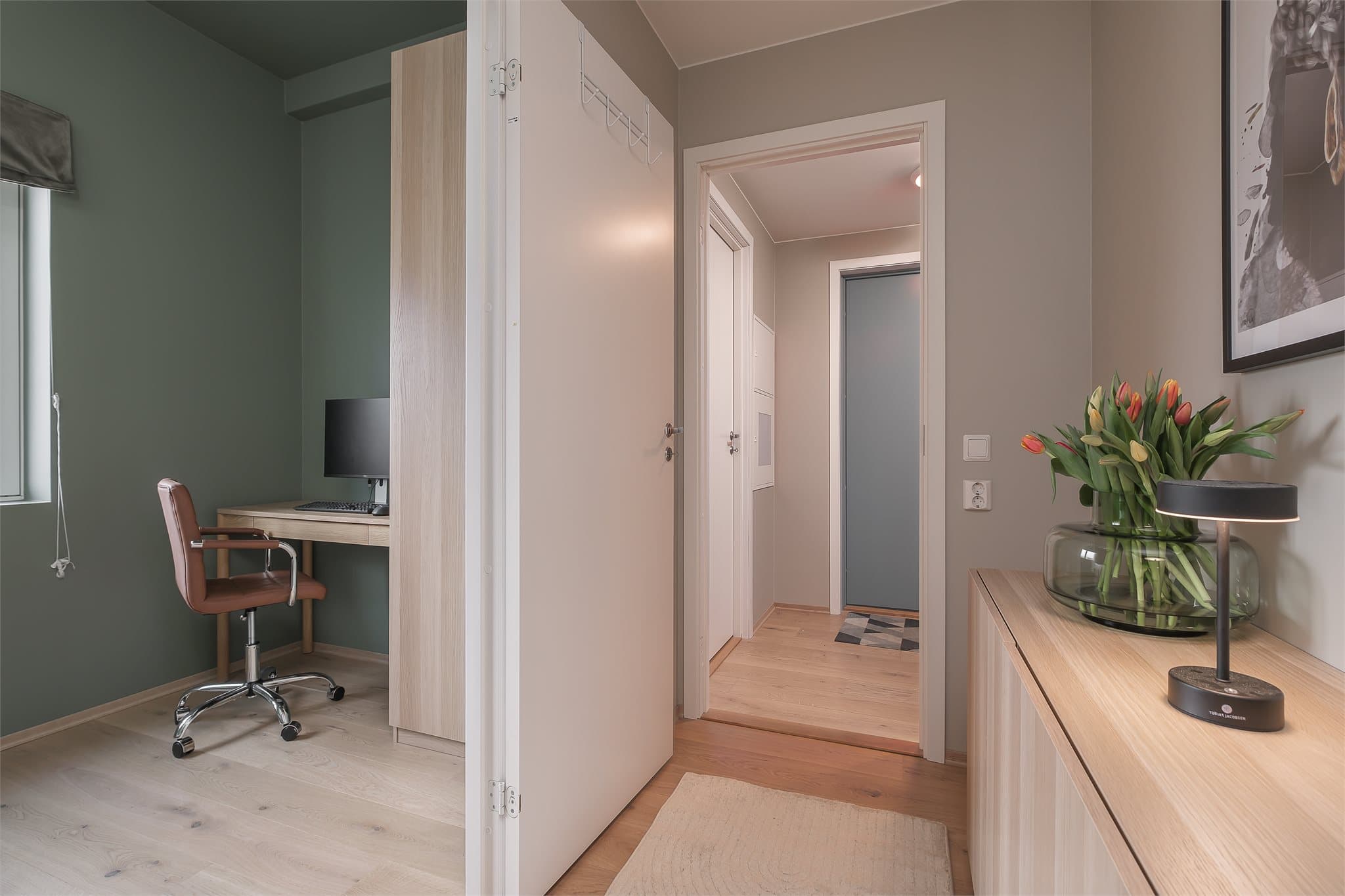 Gangen, som forbinder oppholdsrommene, har plass til praktisk møblering.