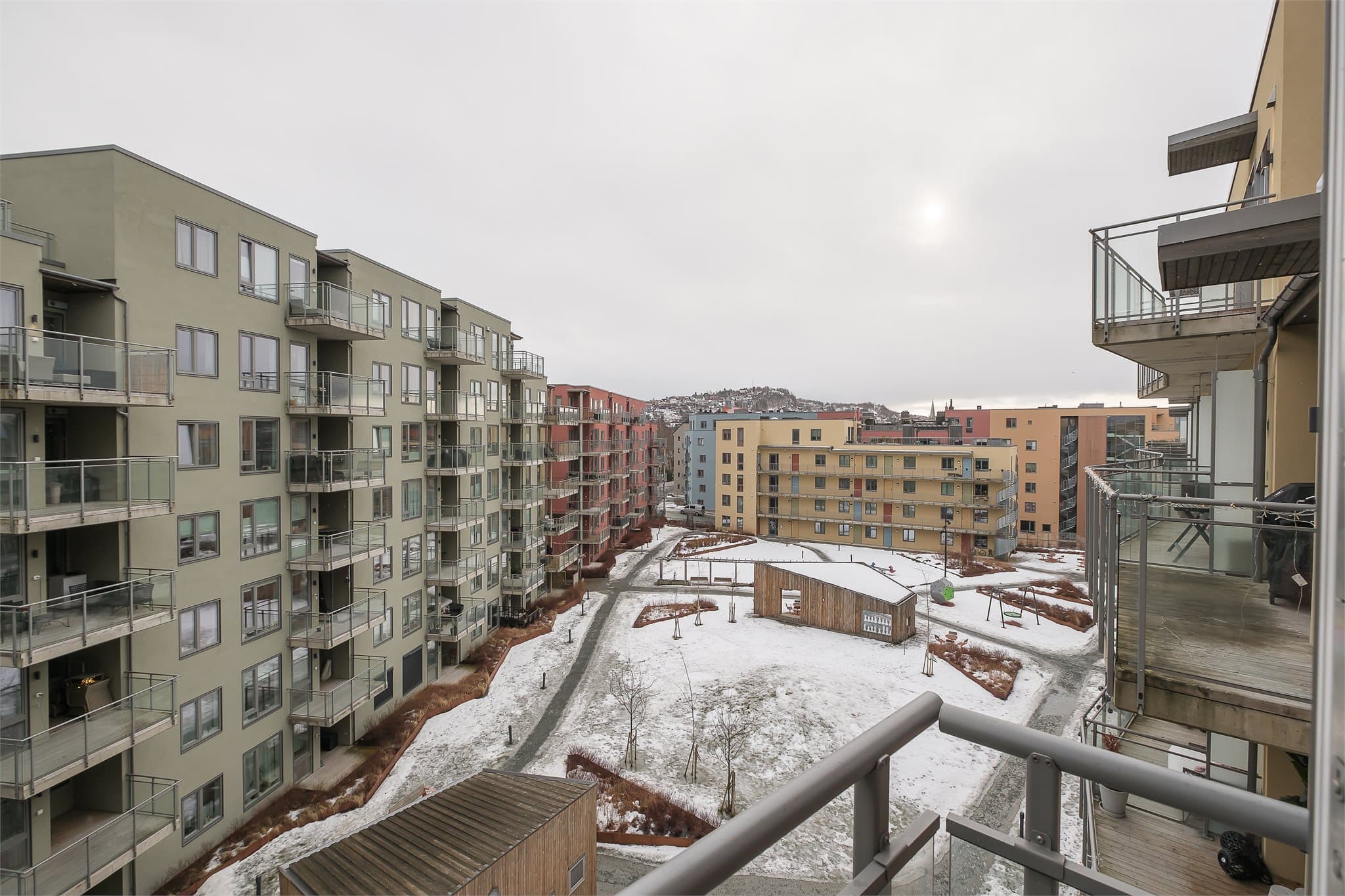 Fra balkongen har man utsikt over sameiets pent opparbeidede fellesarealer, med lekeplass, paviljong, beplantninger og sittegrupper.