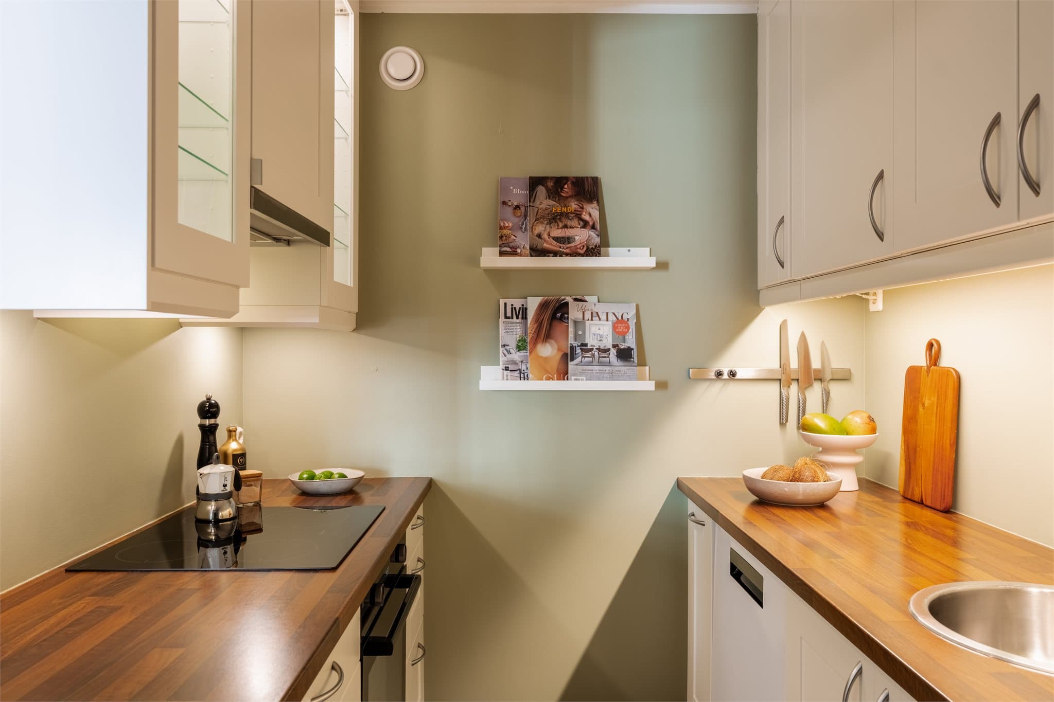 Innredningen er av hvite, lekre fronter samt laminat benkeplate og er utstyrt med platetopp, stekeovn og oppvaskmaskin som medfølger handelen.