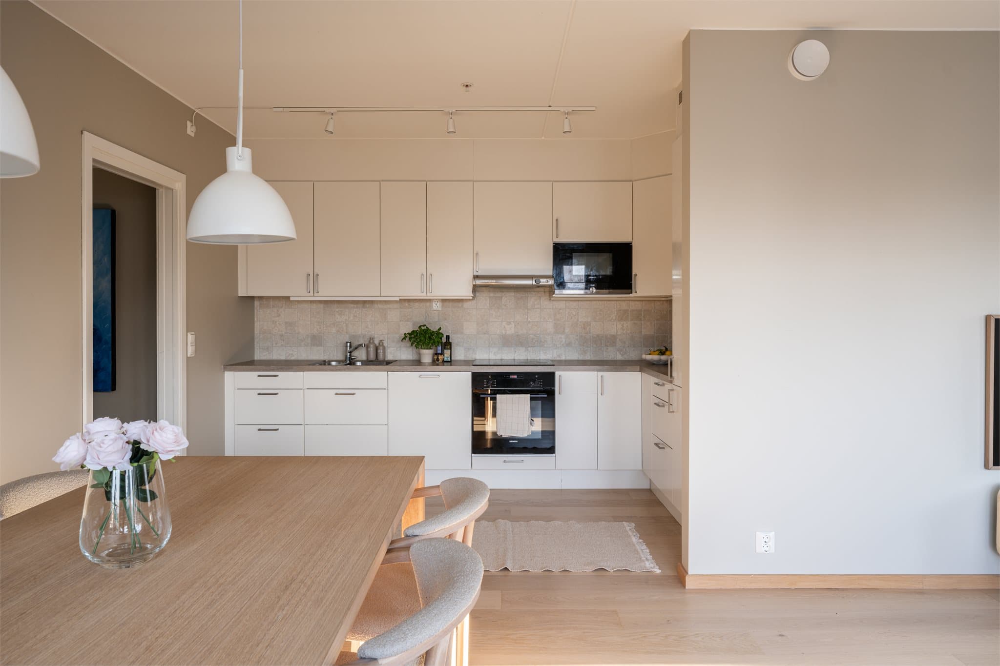 Lyst og moderne kjøkken med glatte skapfronter, god skapplass og romslige arbeidsflater.