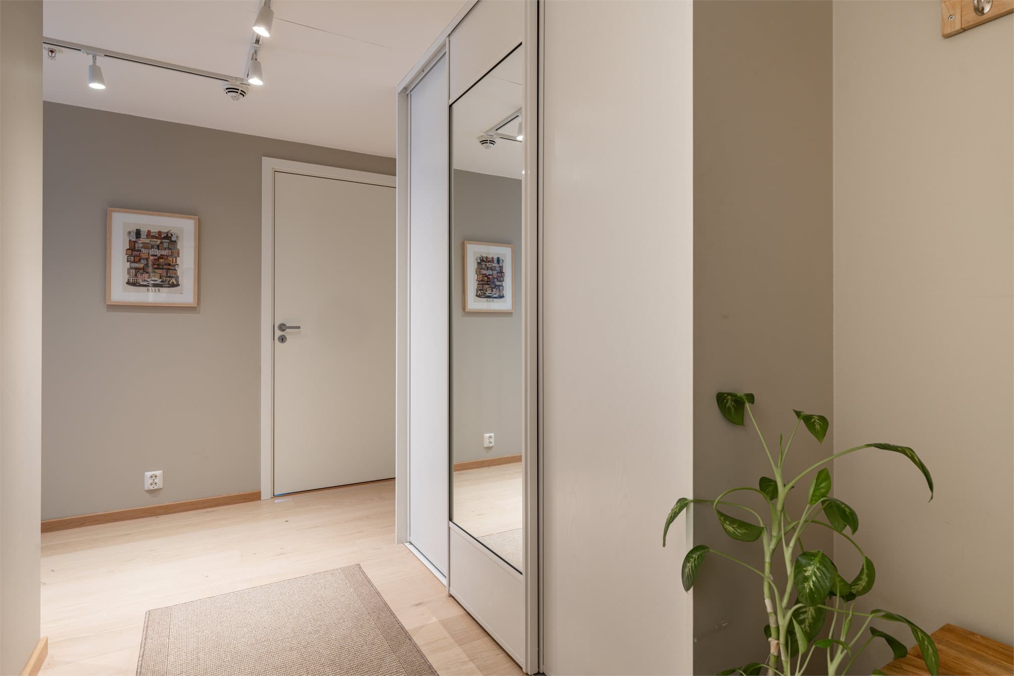 Lys og innbydende entré med god lagringsplass i skyvedørsgarderobe.