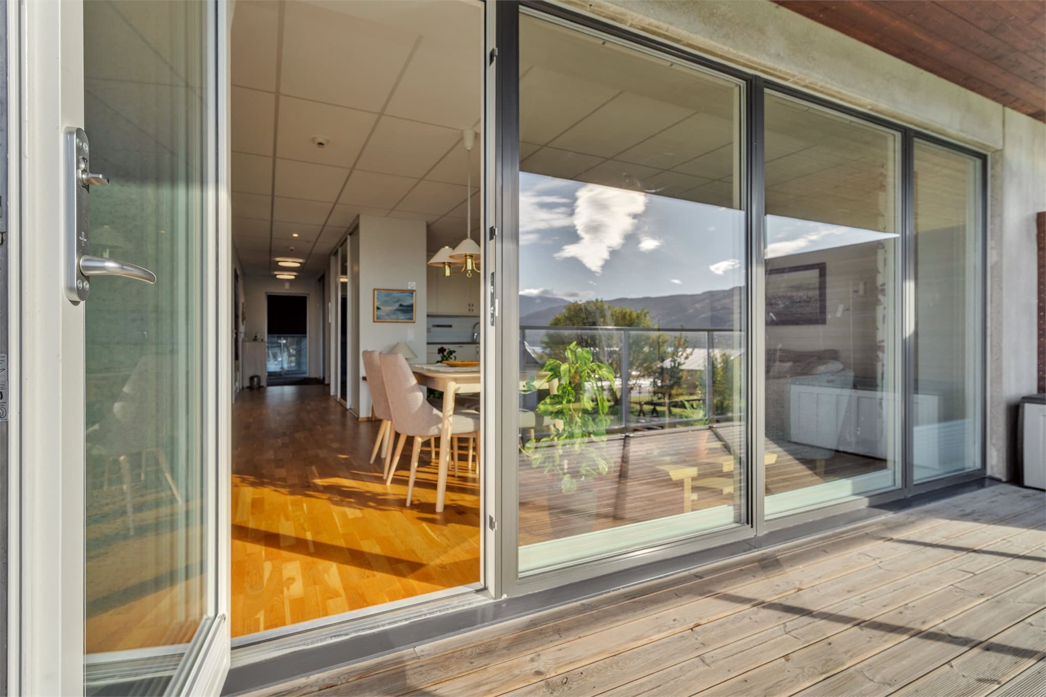 De store glassfeltene knytter verandaen og oppholdsrommet tett sammen.