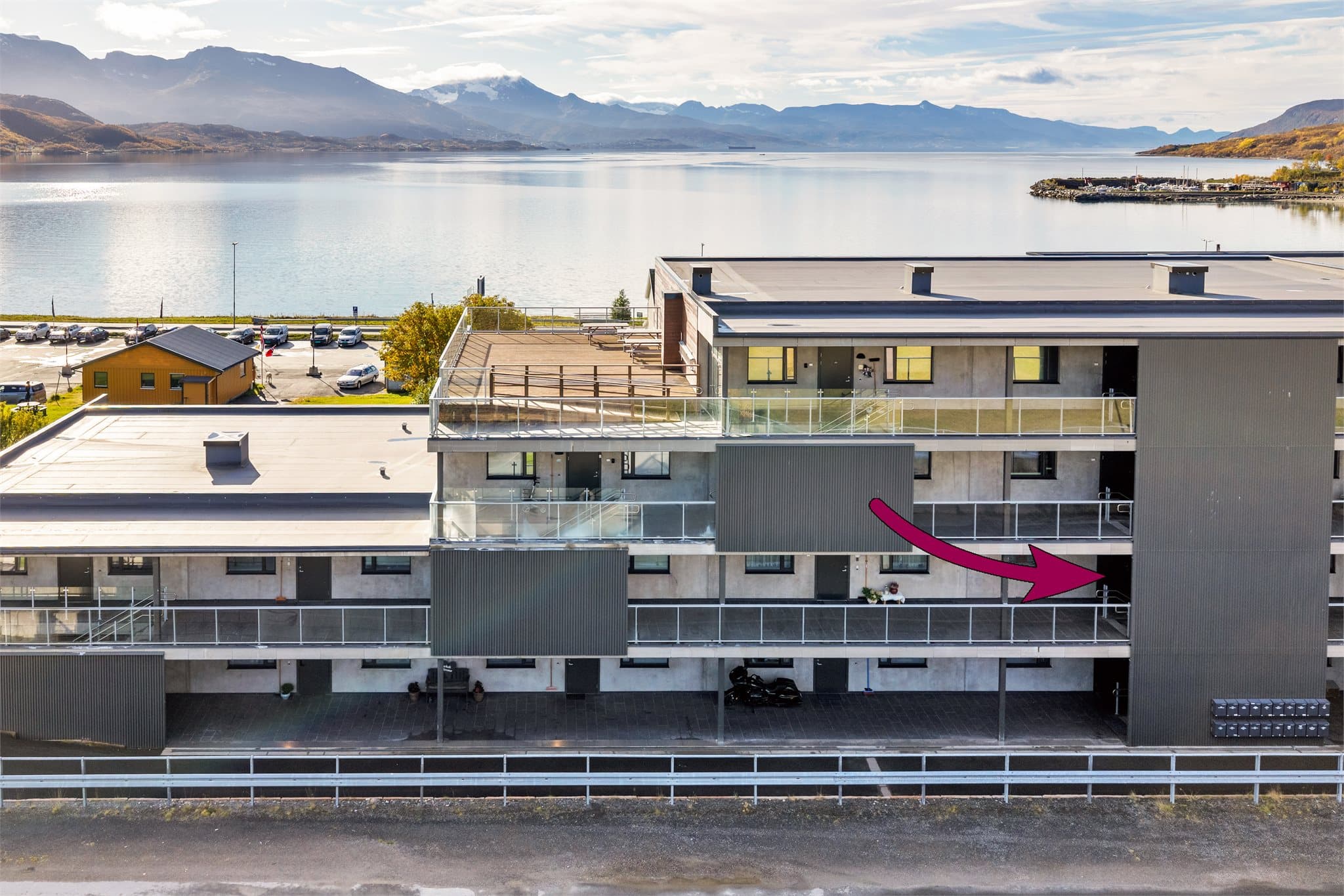 Adkomst via overbygd svalgang i andre etasje, med felles takterrasse på toppen.