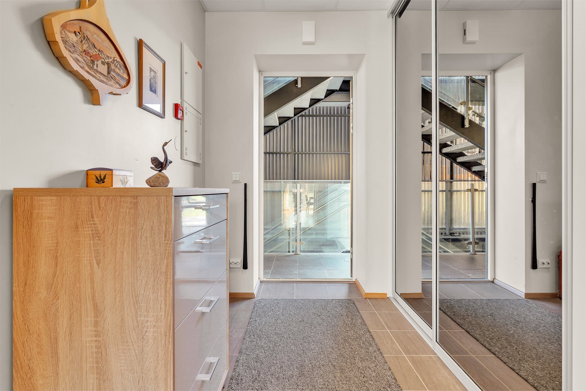 Entréen har flislagt gulv og praktisk skyvedørsgarderobe med speilfronter.