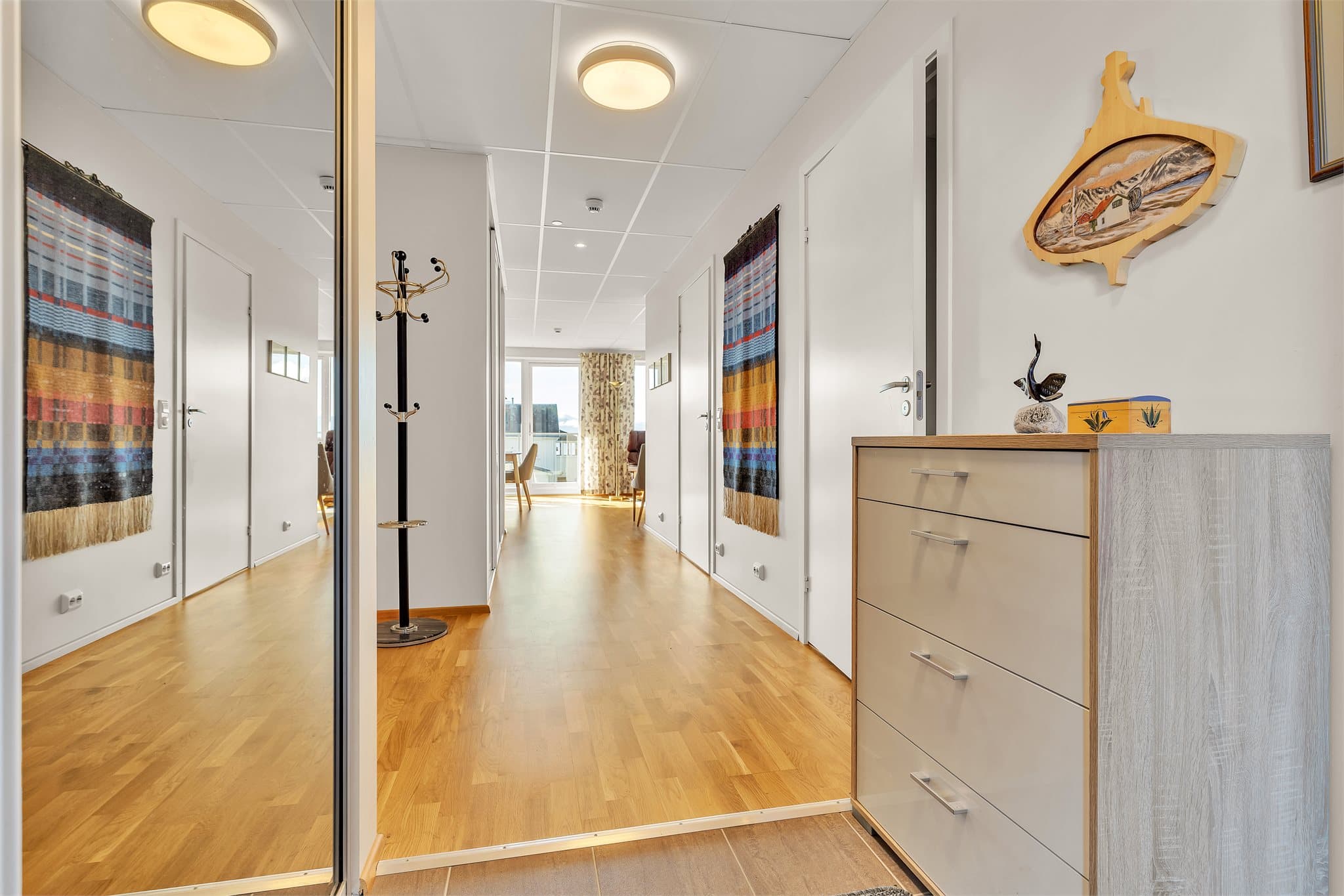 Fra gangen er det åpen passasje videre inn til den lyse stuen.