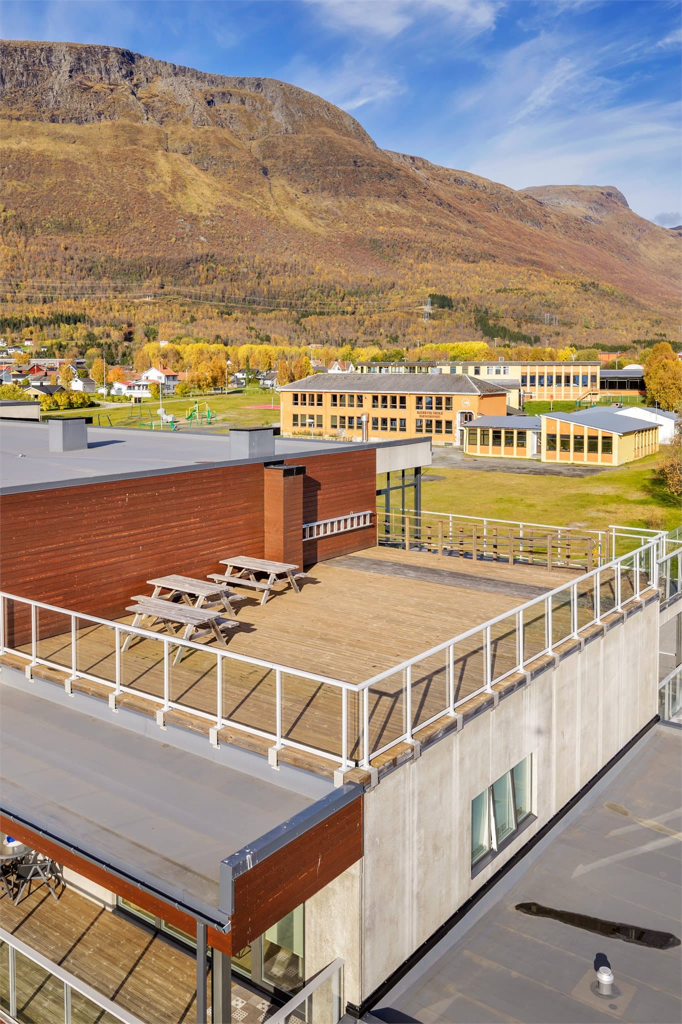 Fra takterrassen ser du mot Bjerkvik skole og fjellandskapet bak bygda.