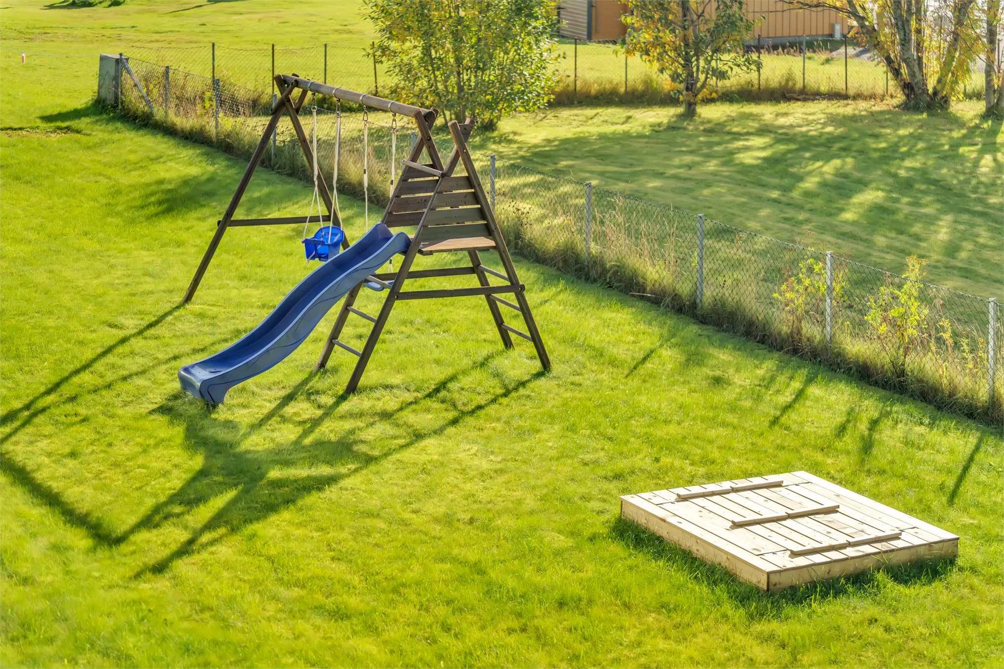 Felles grøntareal med lekestativ og sandkasse på sameiets tomt.