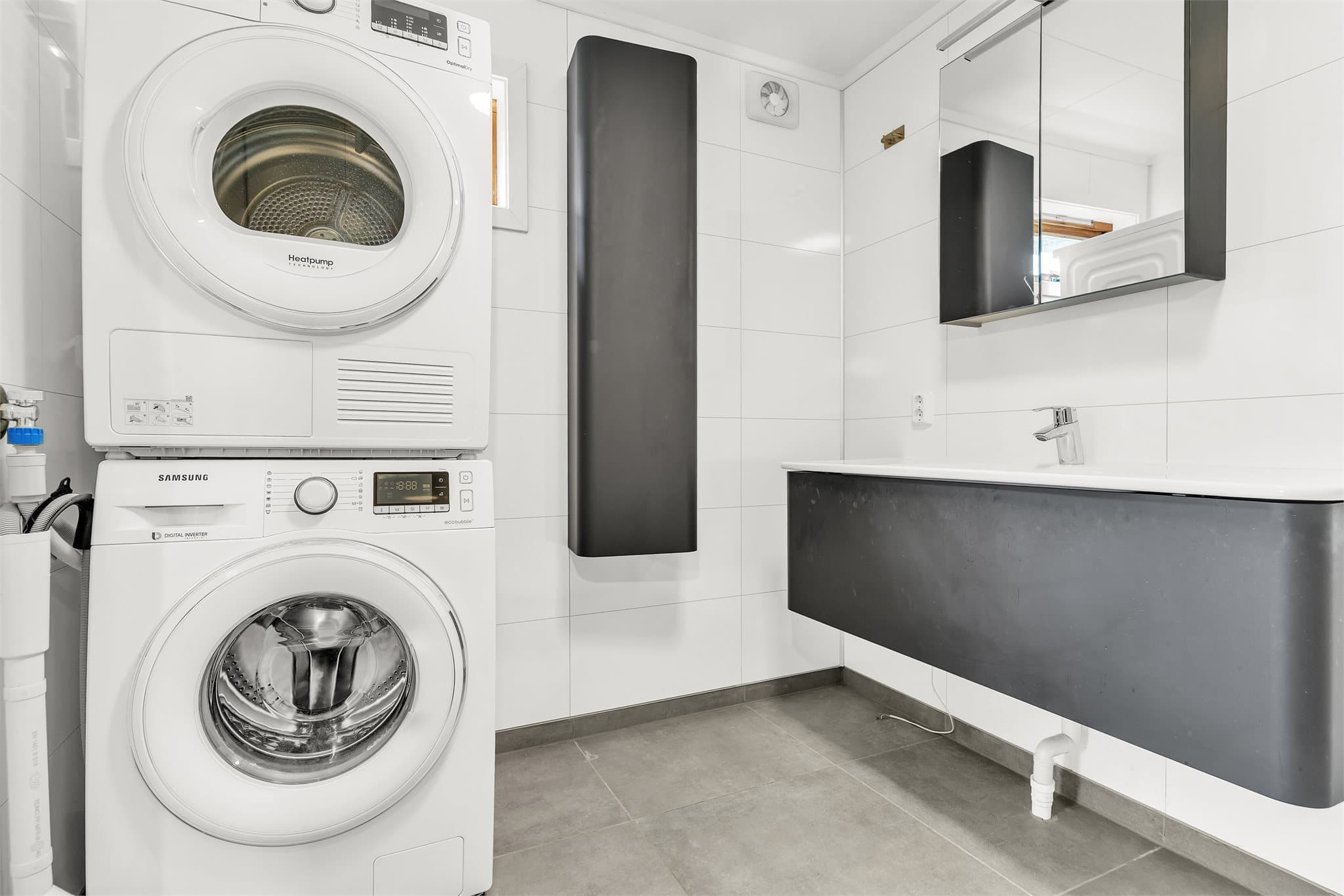 Badet har flislagt gulv med elektriske varmekabler og opplegg for vaskemaskin.