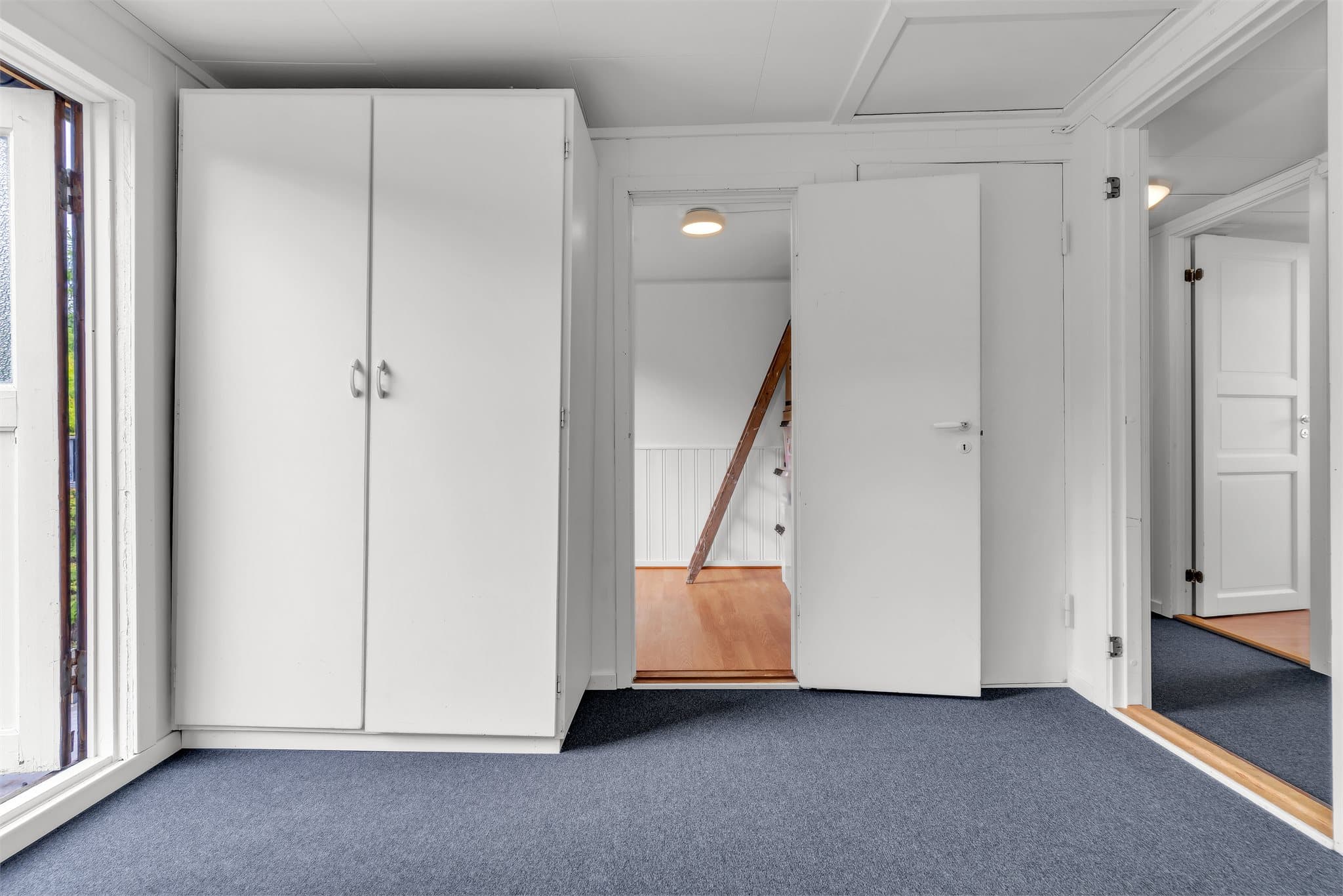Loftsgang sett mot et innredet rom.