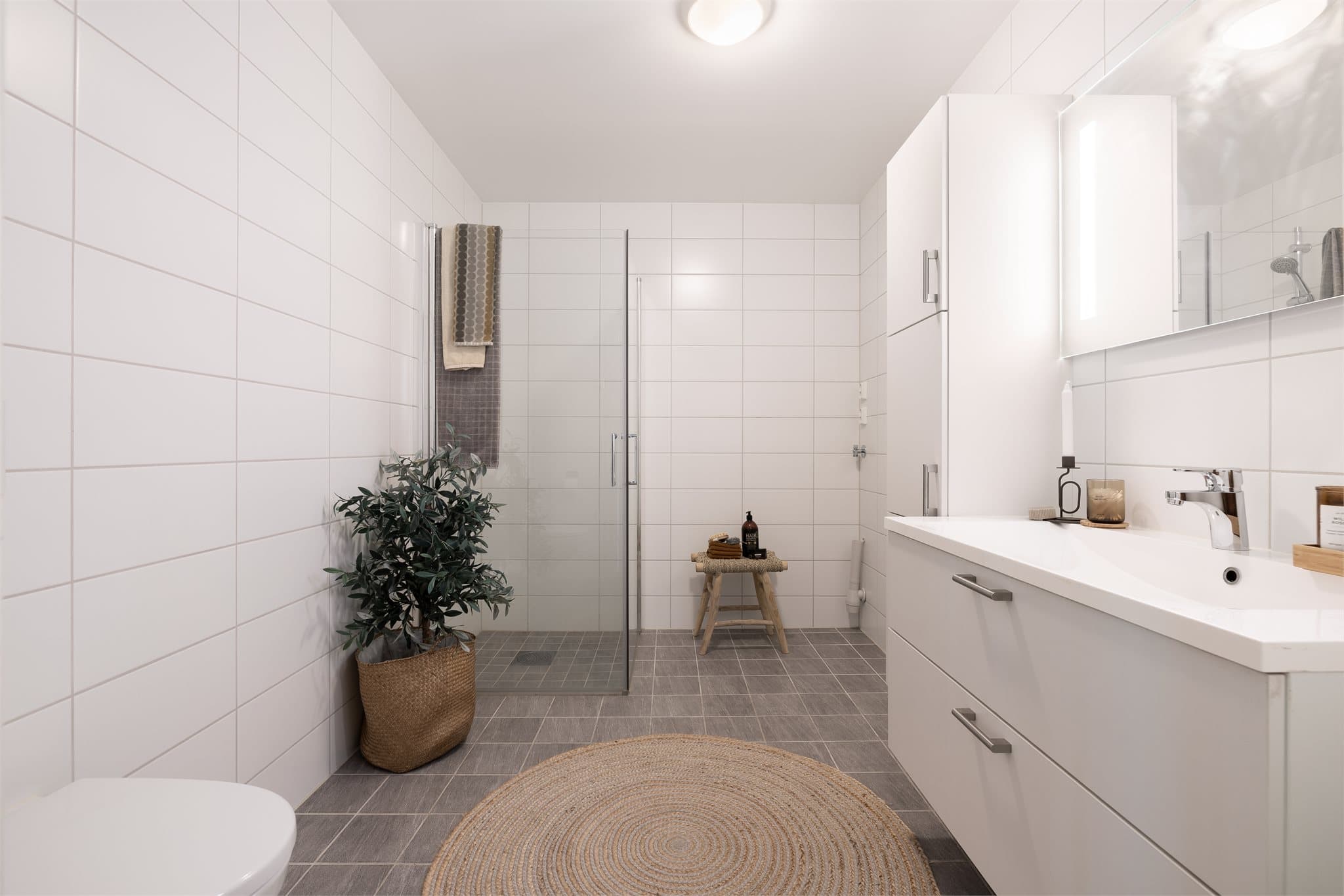 Servantinnredning, dusjhjørne og opplegg for vaskemaskin.