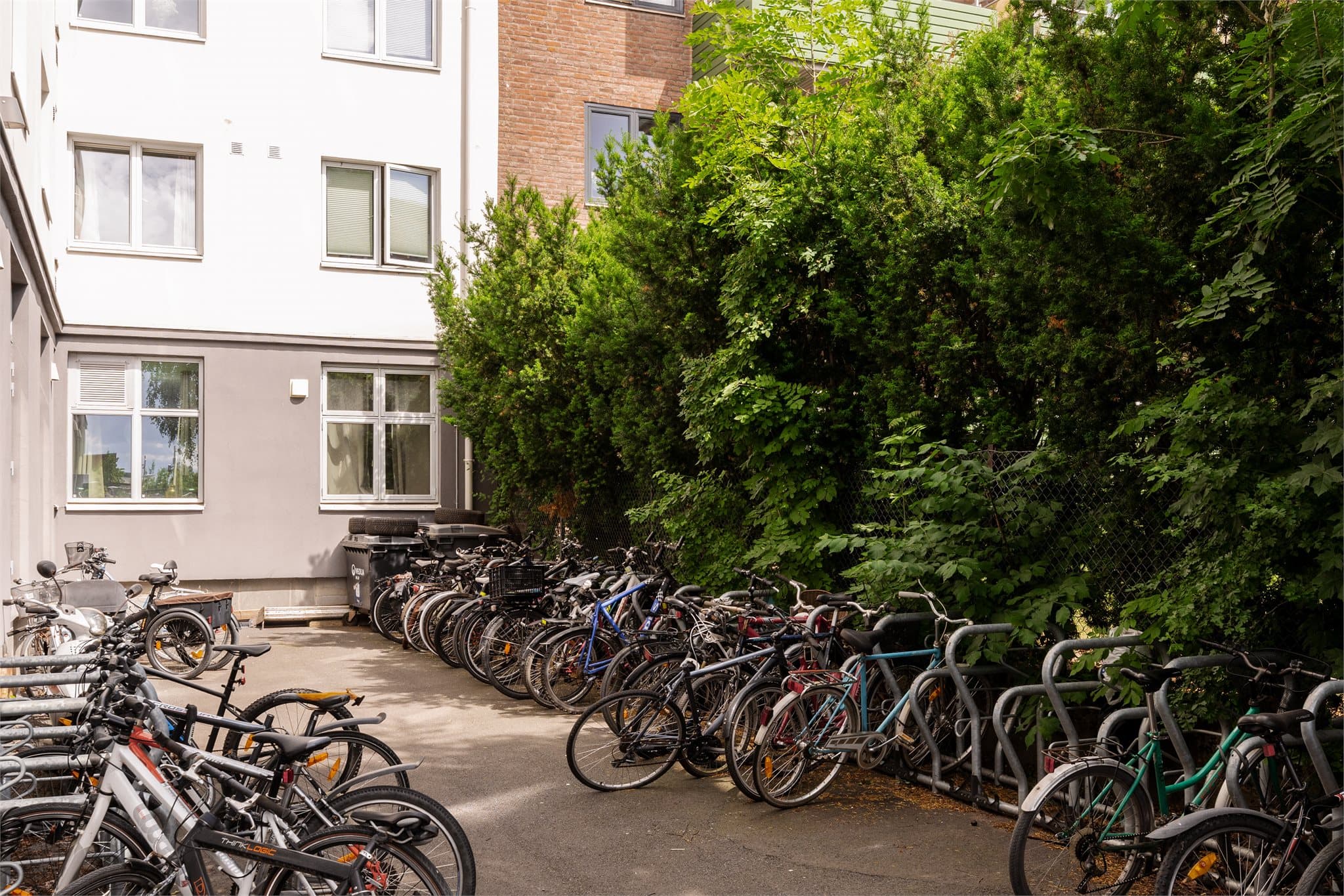 Felles sykkelparkering med lukket port på baksiden av B-inngangen mot barnehagen.