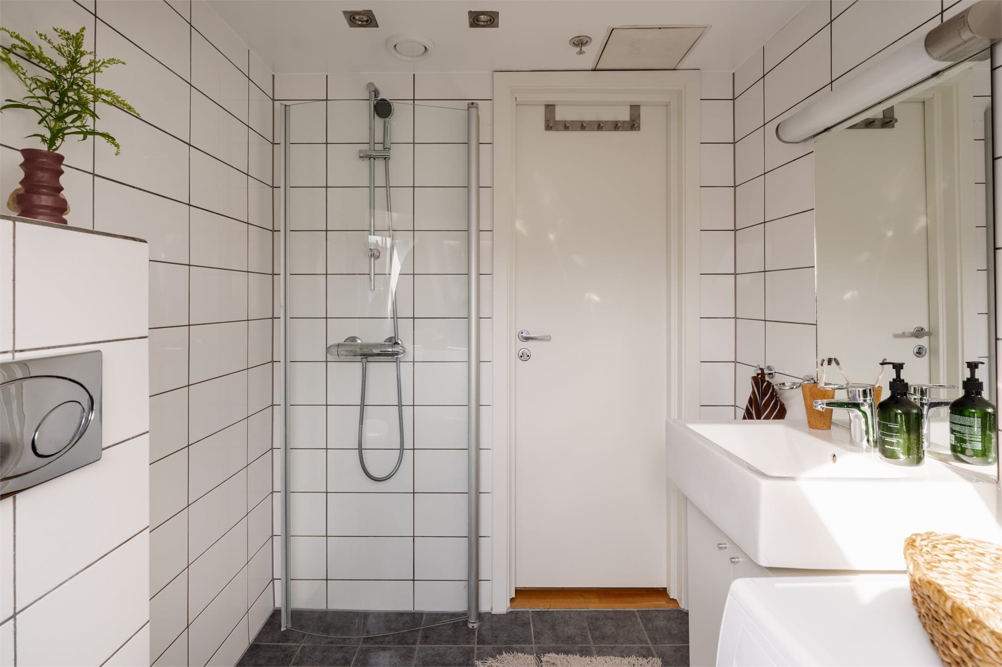 Dusjhjørnet er utstyrt med innfellbare glassvegger og baderomsinnredning med servant.