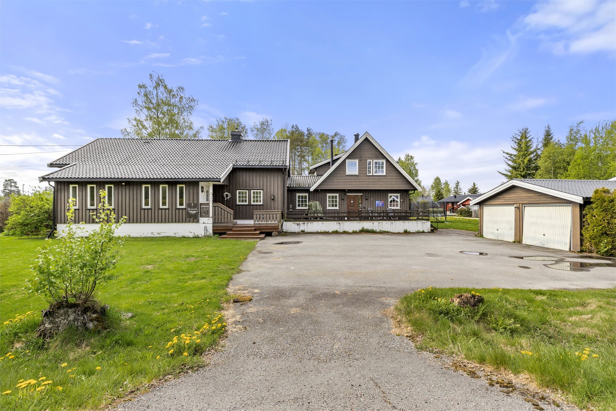 Eiendommen har en romslig, asfaltert gårdsplass og en stor, flat tomt.